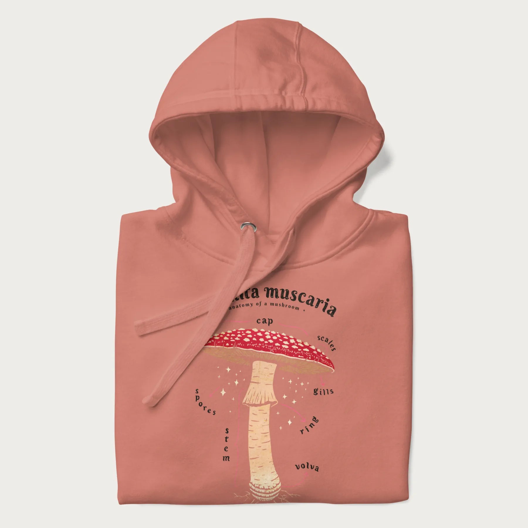 Folded light pink hoodie with a detailed anatomy illustration of an Amanita muscaria mushroom.