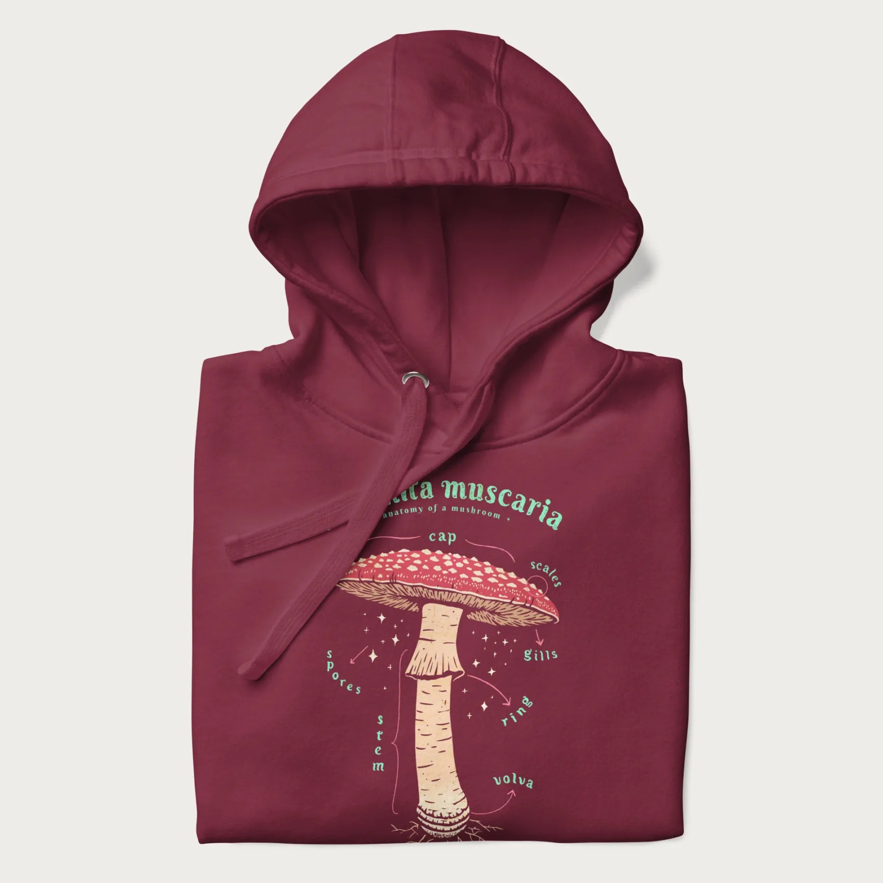 Folded maroon hoodie with a detailed anatomy illustration of an Amanita muscaria mushroom.