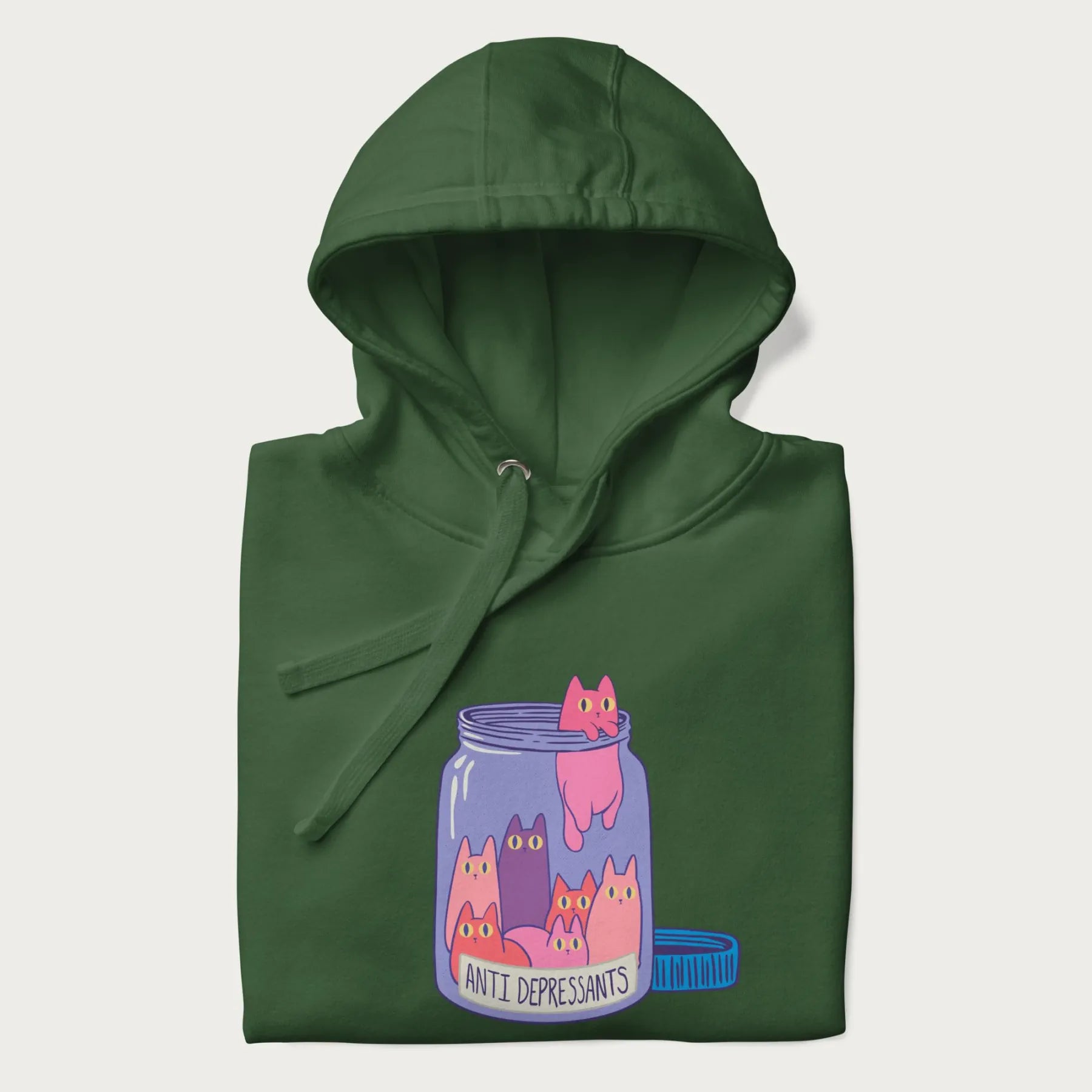 Cartoon cats in a clear jar labeled 'Anti Depressants' printed on a folded dark green hoodie.
