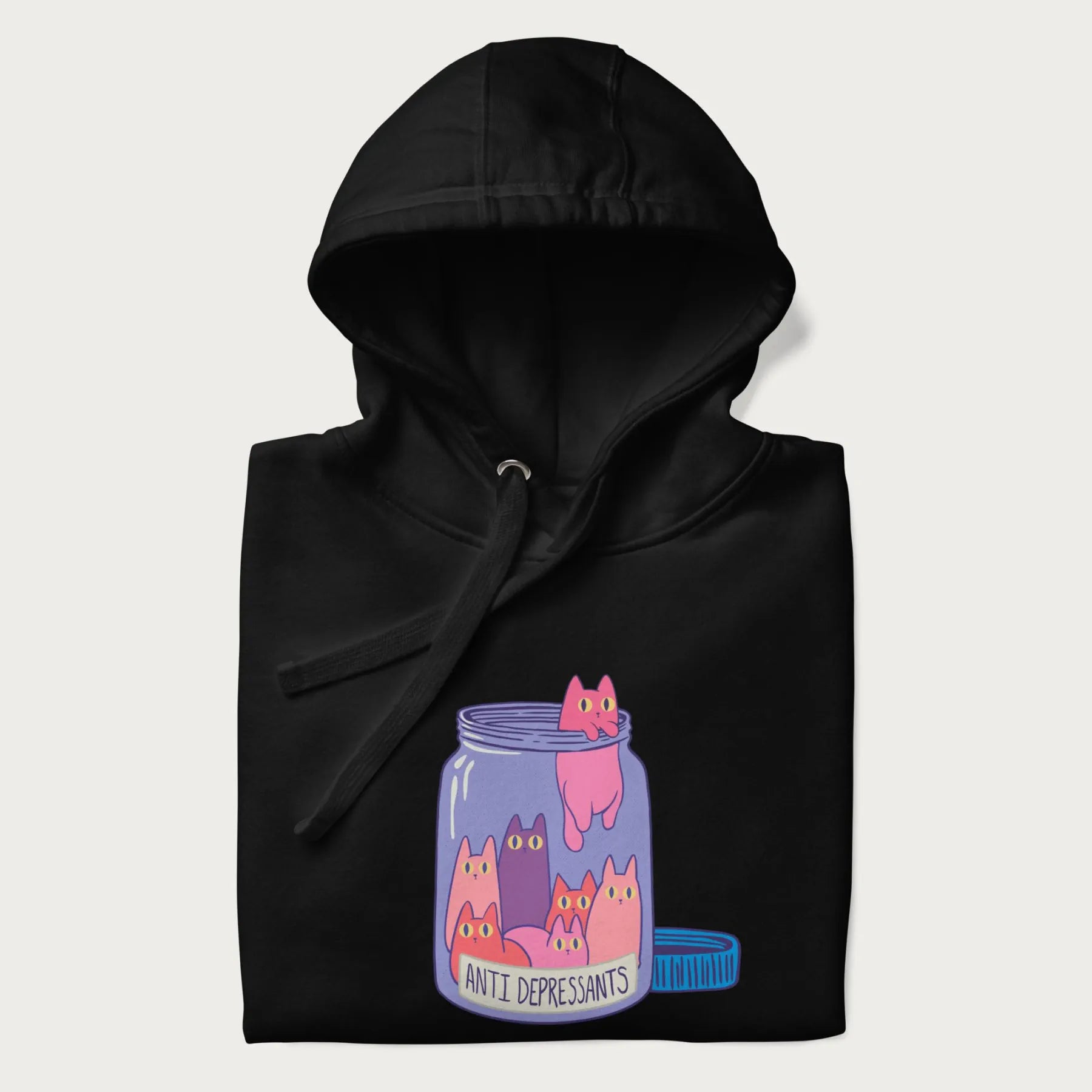 Cartoon cats in a clear jar labeled 'Anti Depressants' printed on a folded black hoodie.