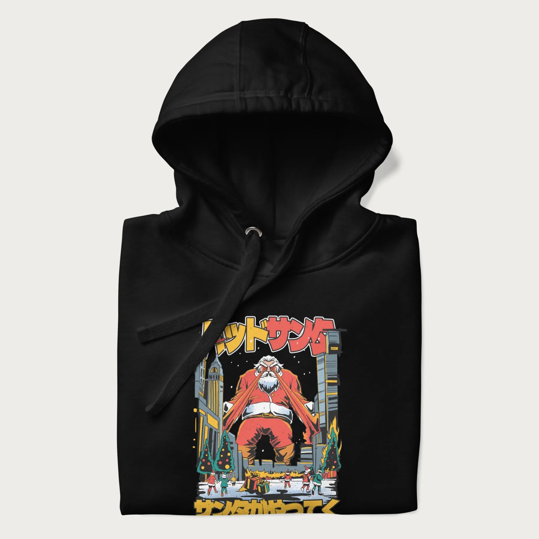 Folded black hoodie with Japanese graphic of Santa Claus with laser eyes attacking a festive city, with the Japanese text 'パッドサンタ' (Bad Santa).