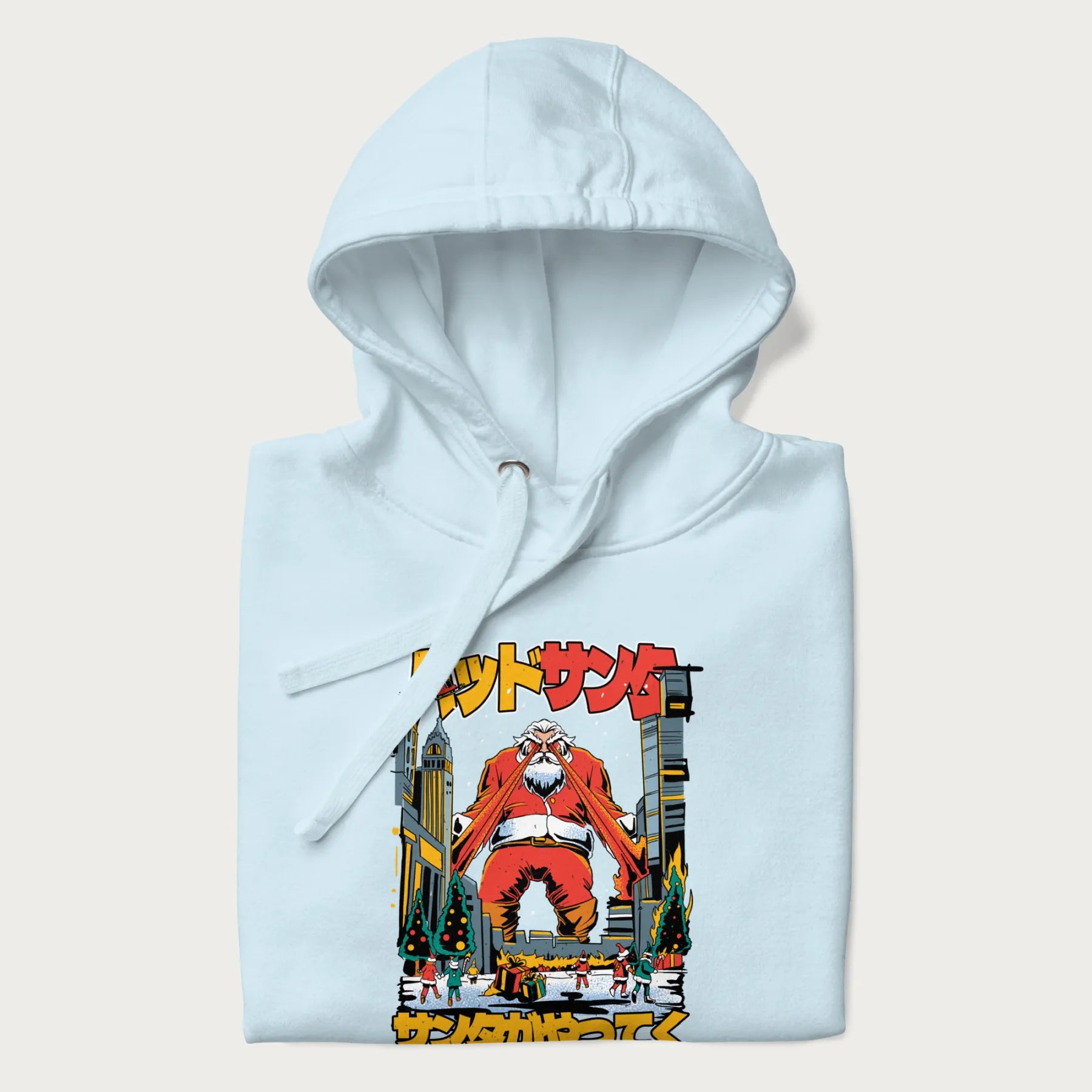 Folded light blue hoodie with Japanese graphic of Santa Claus with laser eyes attacking a festive city, with the Japanese text 'パッドサンタ' (Bad Santa).