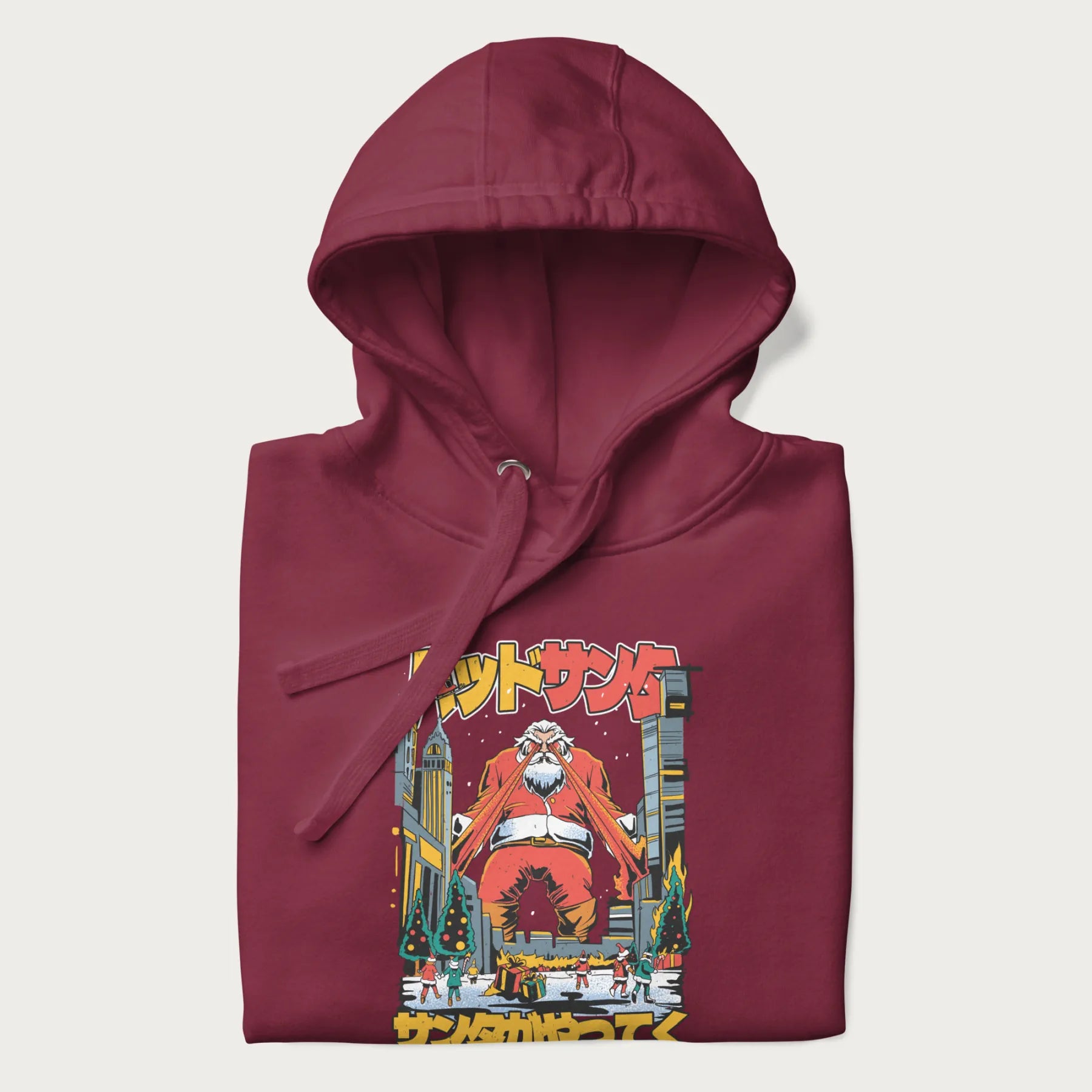 Folded maroon hoodie with Japanese graphic of Santa Claus with laser eyes attacking a festive city, with the Japanese text 'パッドサンタ' (Bad Santa).