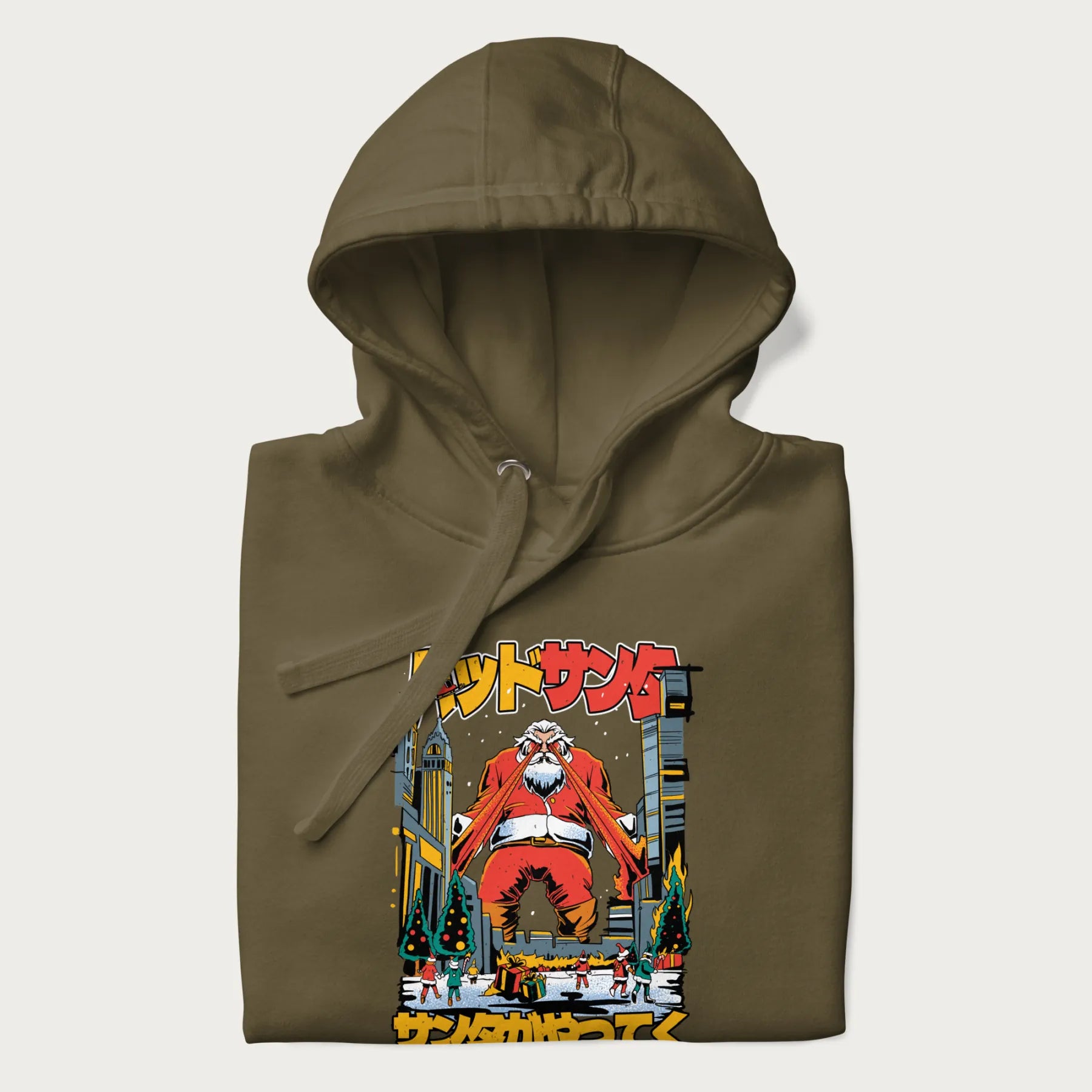 Folded military green hoodie with Japanese graphic of Santa Claus with laser eyes attacking a festive city, with the Japanese text 'パッドサンタ' (Bad Santa).