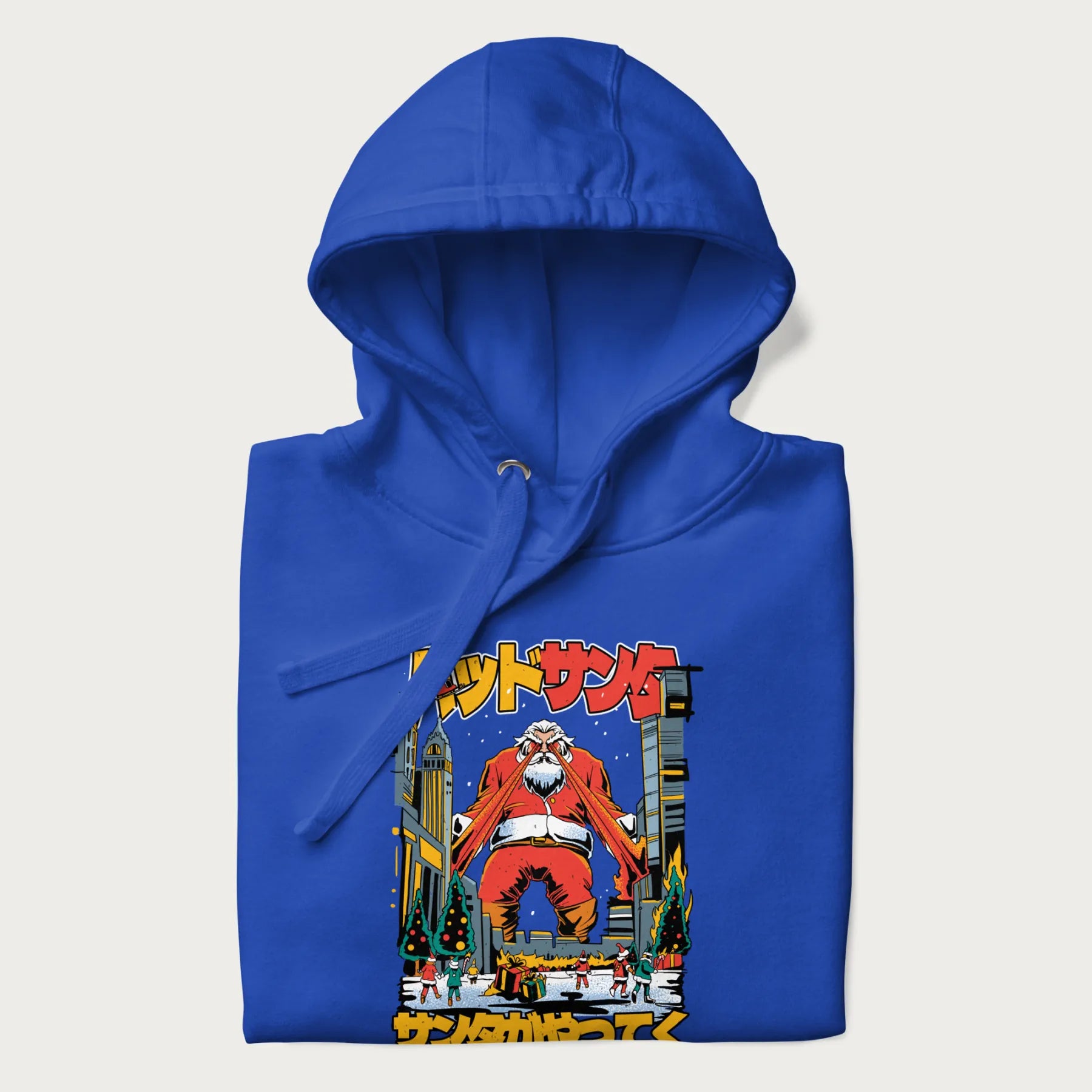 Folded royal blue hoodie with Japanese graphic of Santa Claus with laser eyes attacking a festive city, with the Japanese text 'パッドサンタ' (Bad Santa).