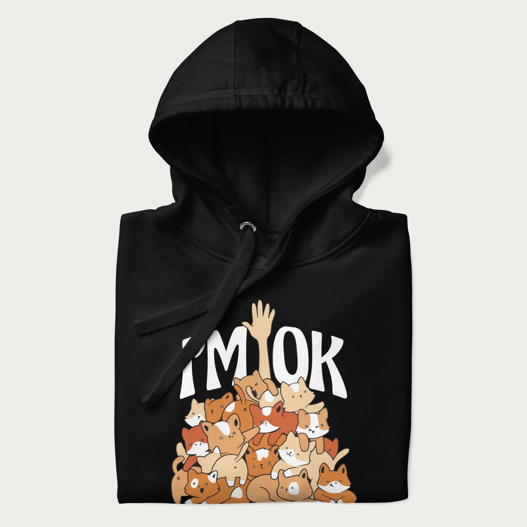 Folded black hoodie with a graphic of kittens piled on top of a person with "I'M OK" in large letters.