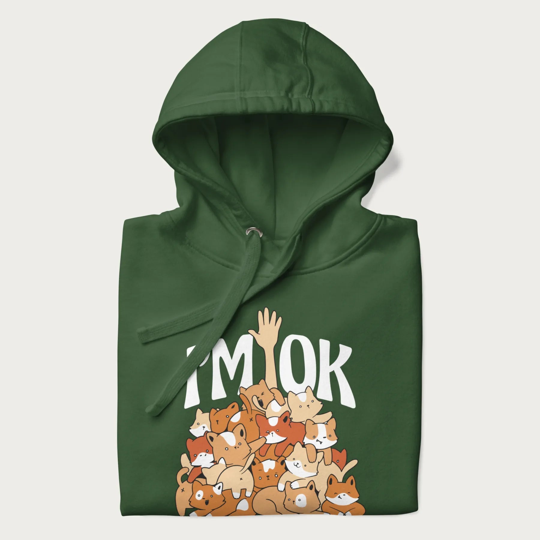 Folded forest green hoodie with a graphic of kittens piled on top of a person with "I'M OK" in large letters.