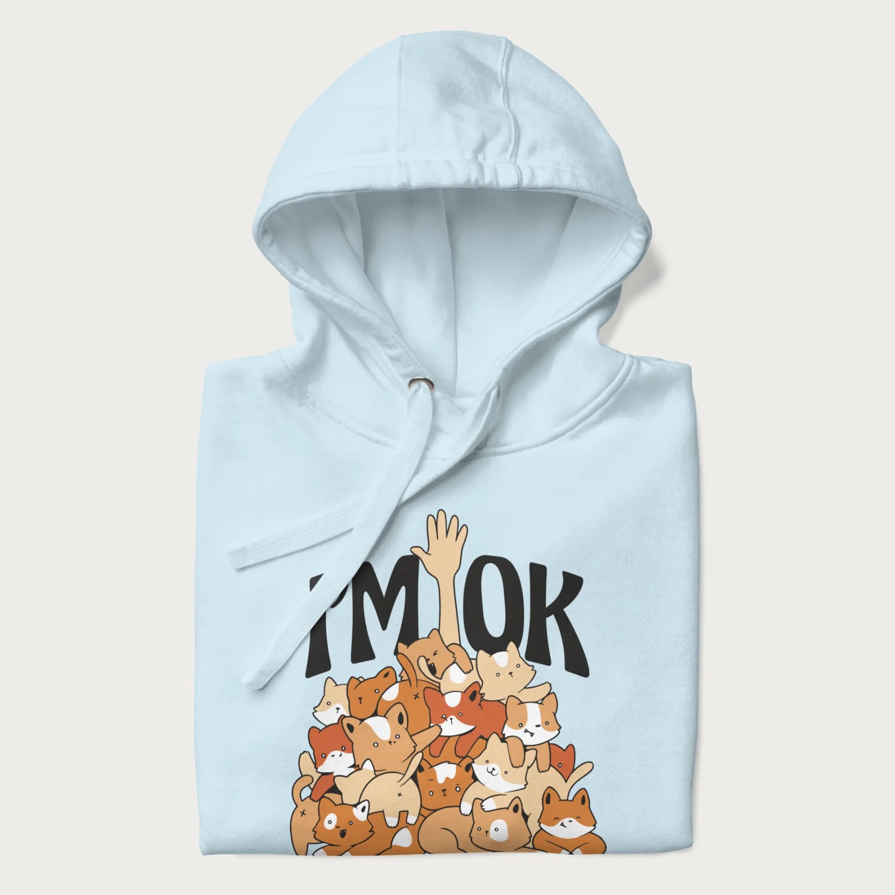Folded light blue hoodie with a graphic of kittens piled on top of a person with "I'M OK" in large letters.