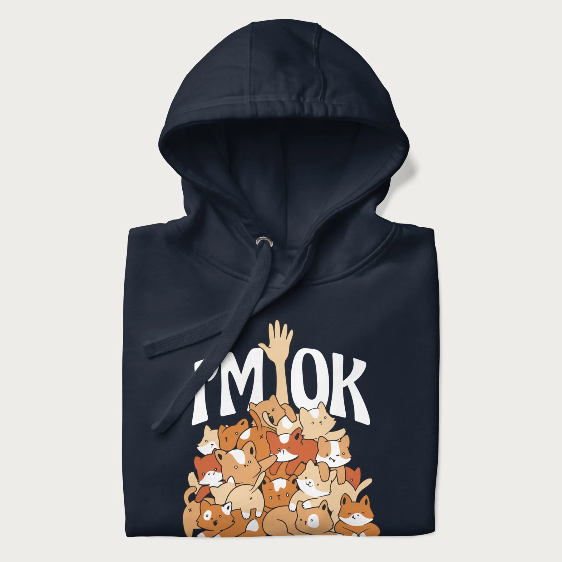 Folded navy blue hoodie with a graphic of kittens piled on top of a person with "I'M OK" in large letters.