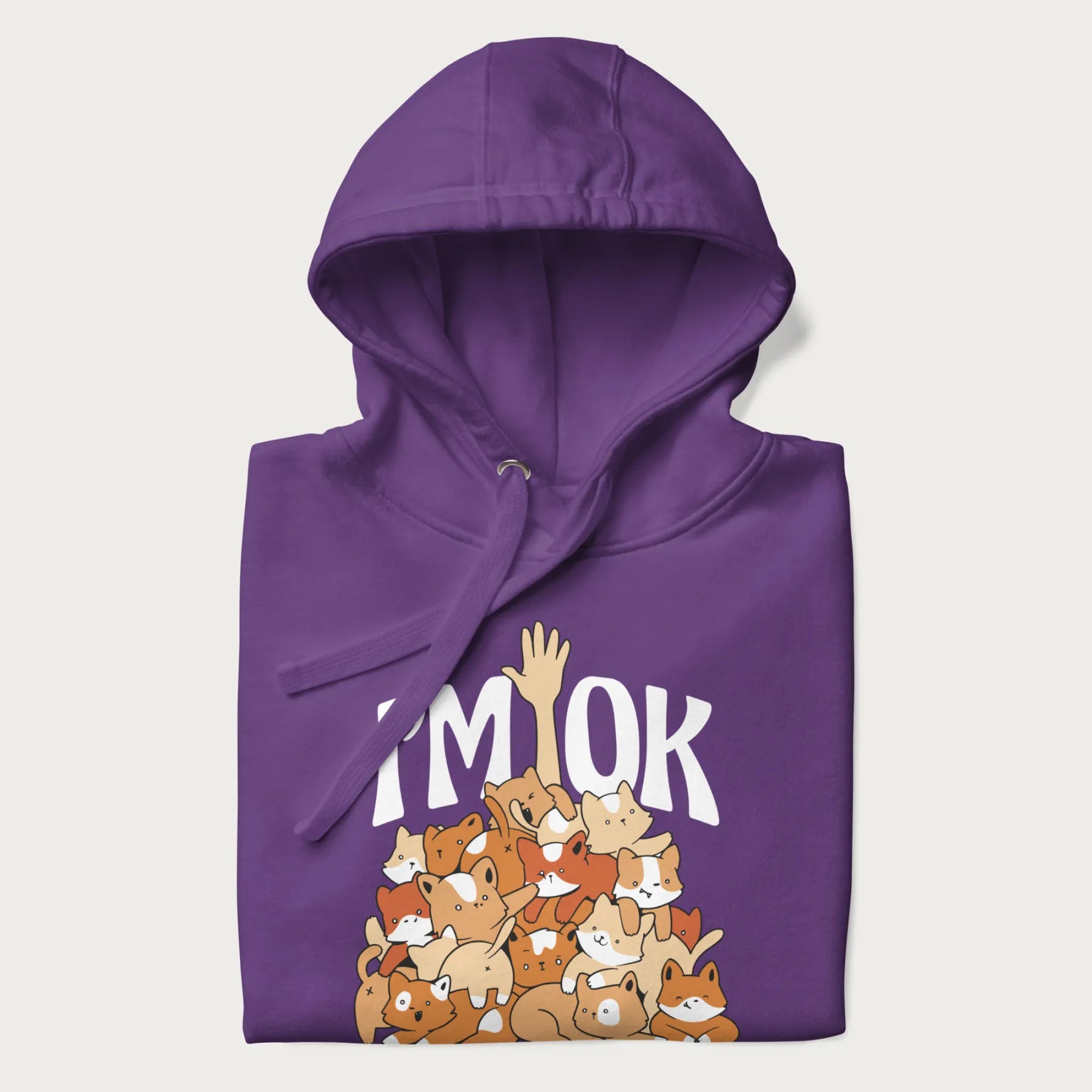 Folded purple hoodie with a graphic of kittens piled on top of a person with "I'M OK" in large letters.