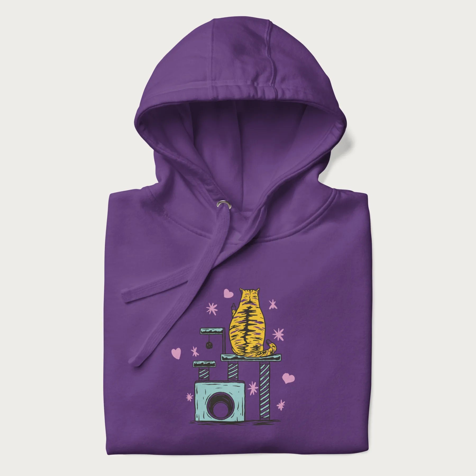 Folded purple hoodie with graphic of a tabby cat on a scratching post, raising its middle finger.