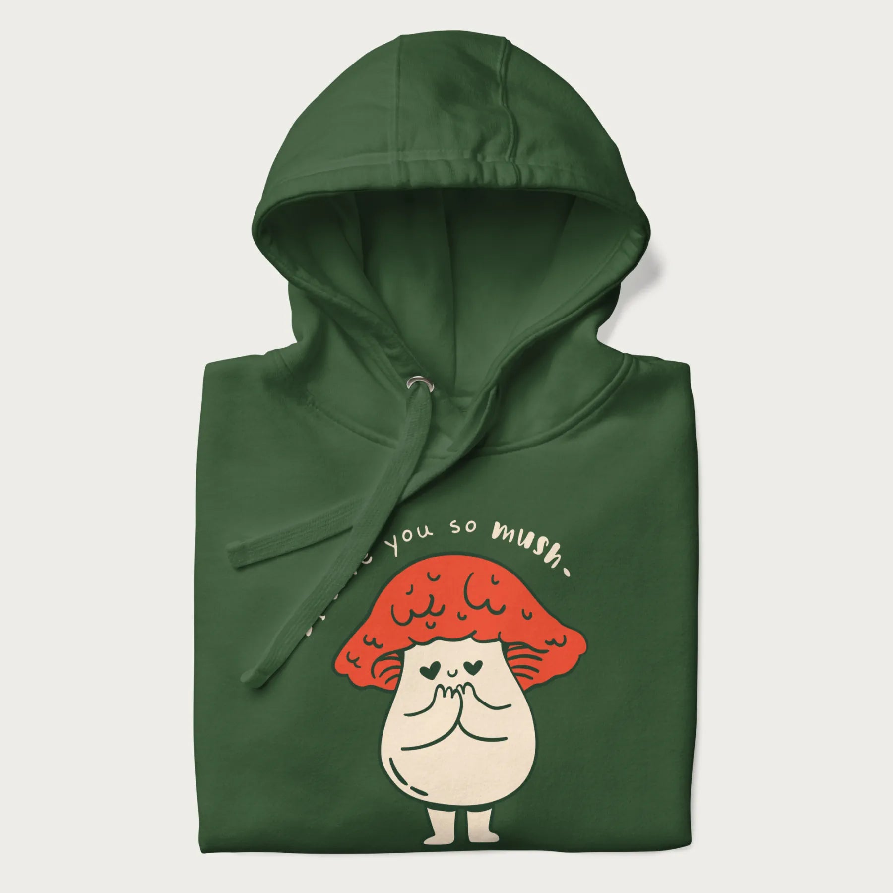 Folded forest green hoodie with a graphic of a cute mushroom character with a red cap and heart-shaped eyes, and the text 'I Love You So Mush'.