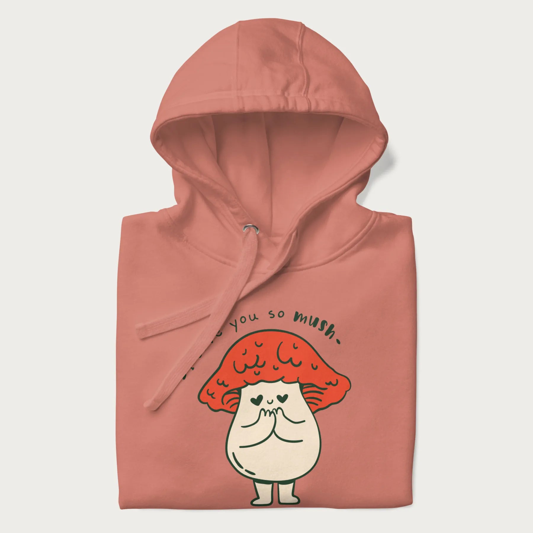 Folded light pink hoodie with a graphic of a cute mushroom character with a red cap and heart-shaped eyes, and the text 'I Love You So Mush'.