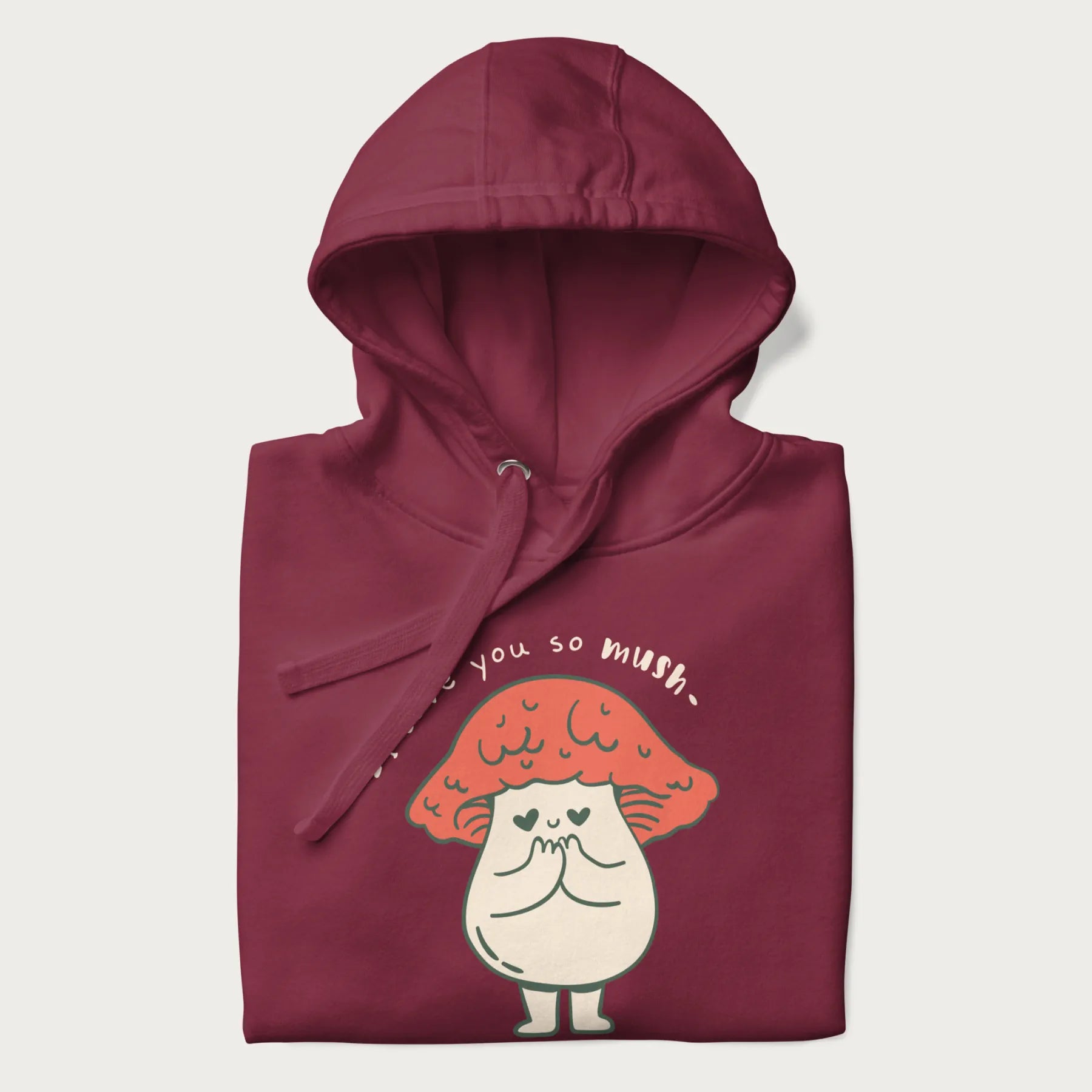 Folded maroon hoodie with a graphic of a cute mushroom character with a red cap and heart-shaped eyes, and the text 'I Love You So Mush'.