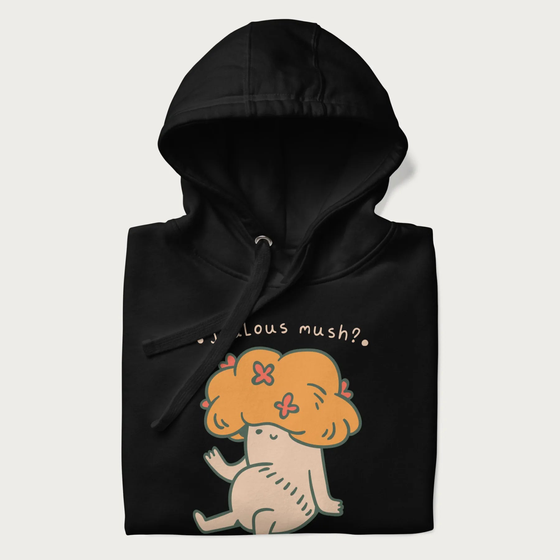 Folded black hoodie with a graphic of a mushroom character with an orange cap and the text 'Jealous mush?'.
