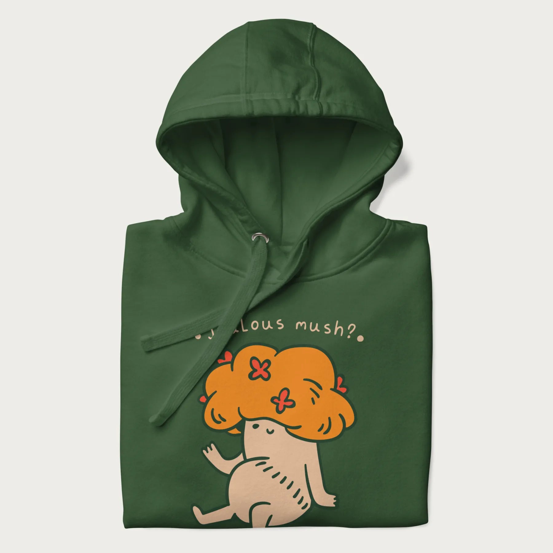 Folded forest green hoodie with a graphic of a mushroom character with an orange cap and the text 'Jealous mush?'.