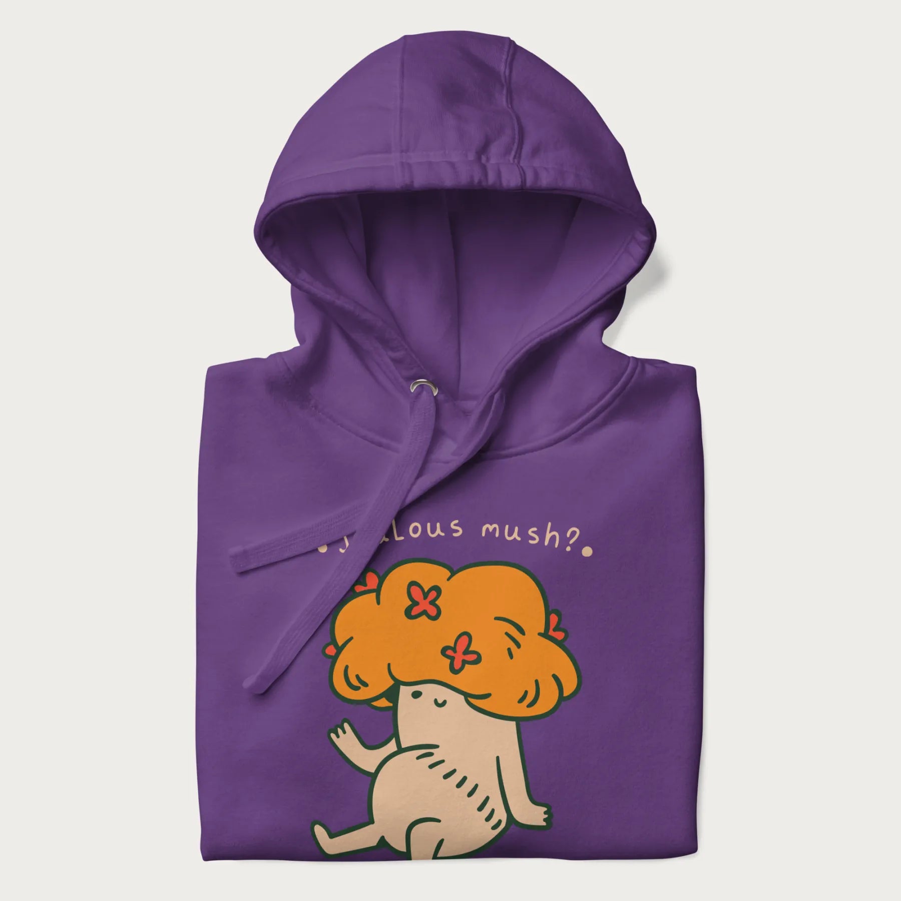 Folded purple hoodie with a graphic of a mushroom character with an orange cap and the text 'Jealous mush?'.