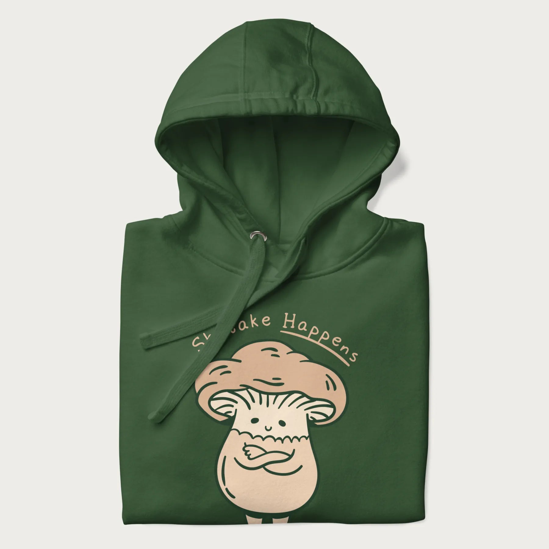 Folded forest green hoodie with a graphic of an adorable mushroom character and the text 'Shiitake Happens'.