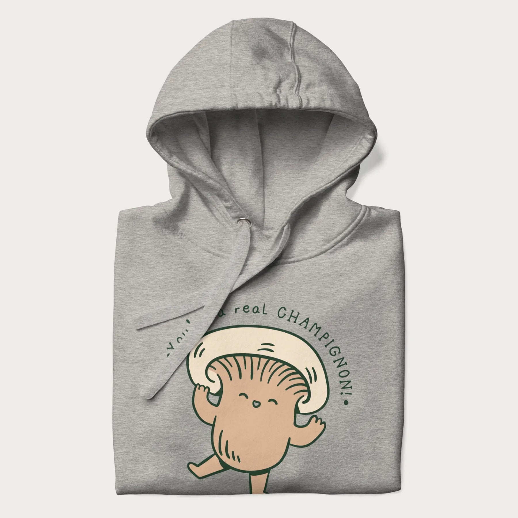 Folded light grey hoodie with a graphic of an adorable mushroom character and the text 'You're a real CHAMPIGNON!'.