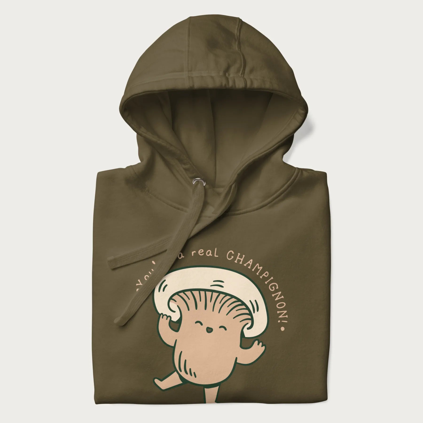Folded military green hoodie with a graphic of an adorable mushroom character and the text 'You're a real CHAMPIGNON!'.
