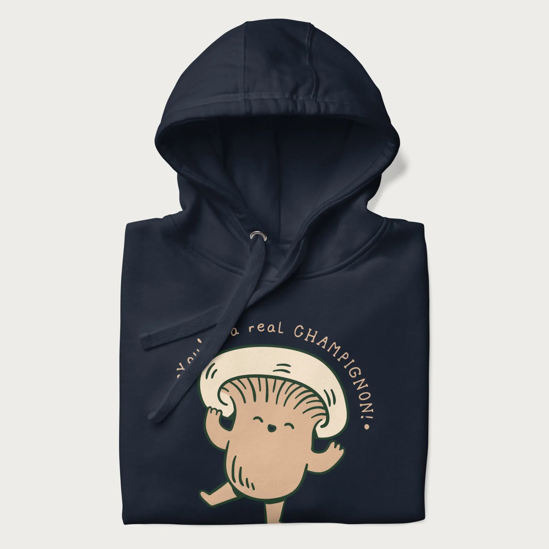 Folded navy blue hoodie with a graphic of an adorable mushroom character and the text 'You're a real CHAMPIGNON!'.