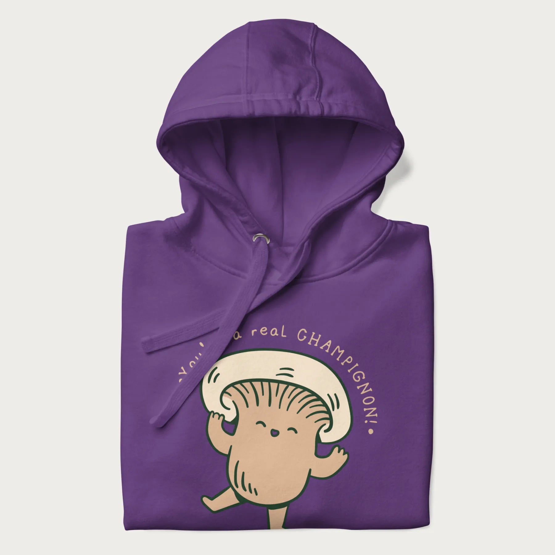 Folded purple hoodie with a graphic of an adorable mushroom character and the text 'You're a real CHAMPIGNON!'.