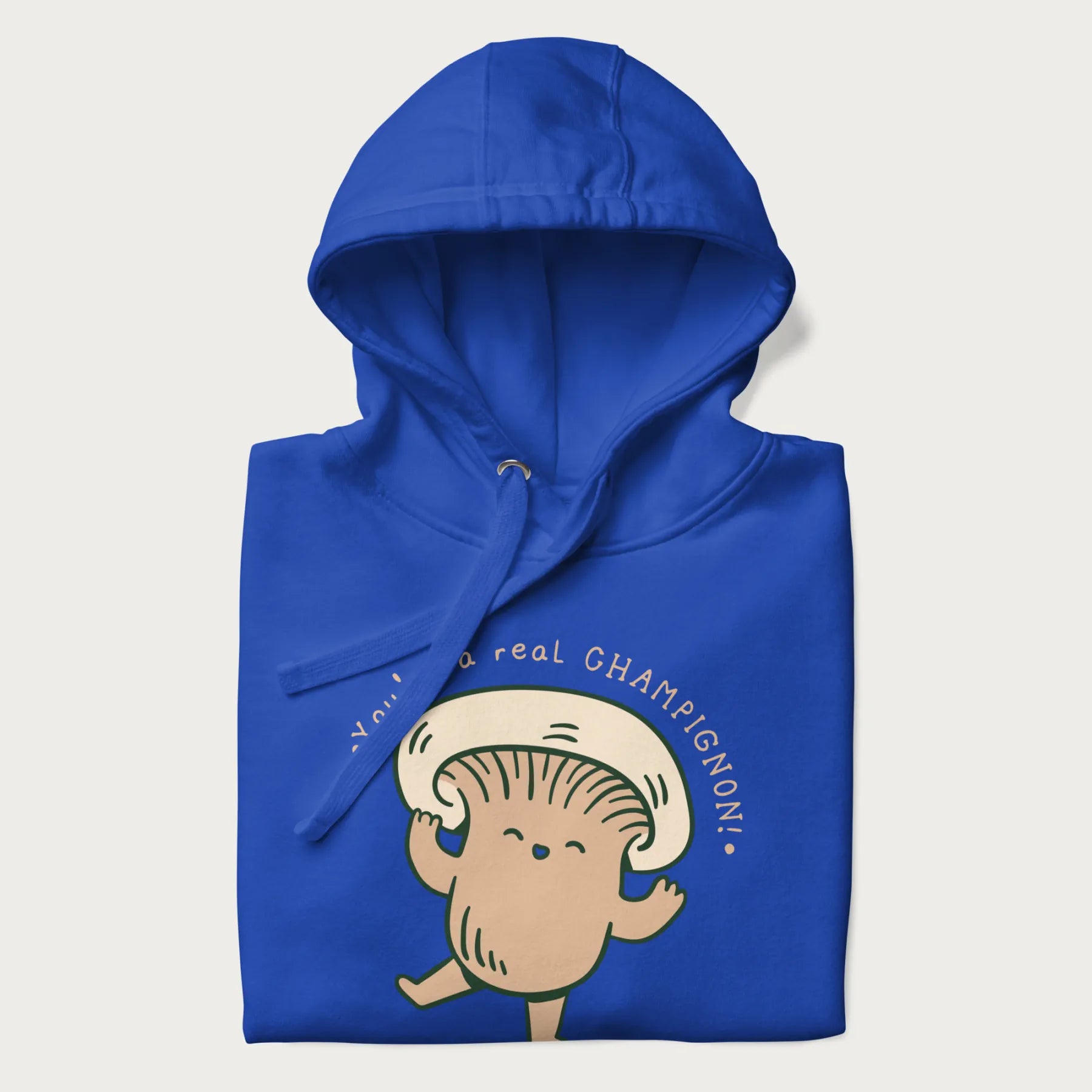 Folded royal blue hoodie with a graphic of an adorable mushroom character and the text 'You're a real CHAMPIGNON!'.