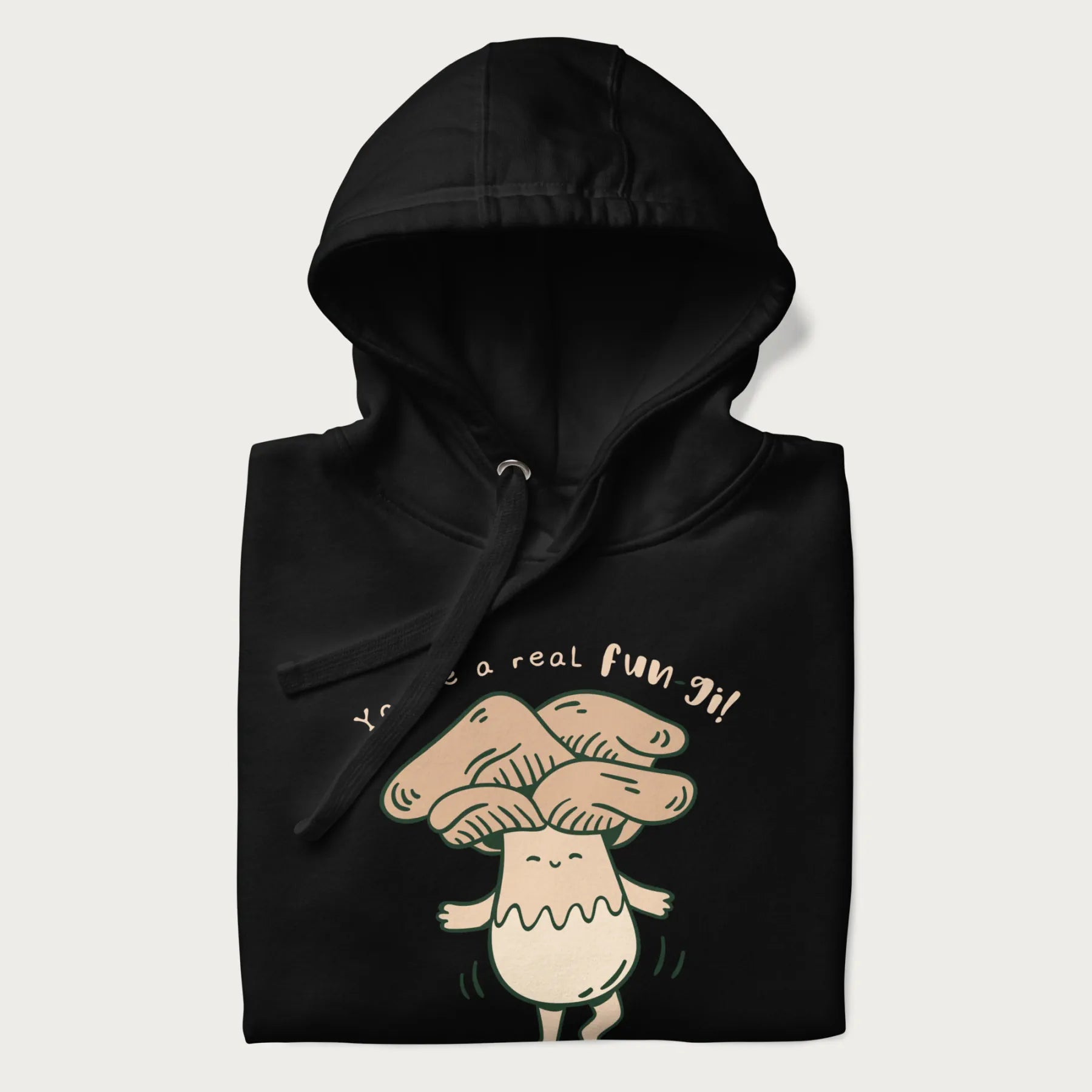 Folded black hoodie with a graphic of a happy mushroom character and the text 'You're a real fun-gi!'.