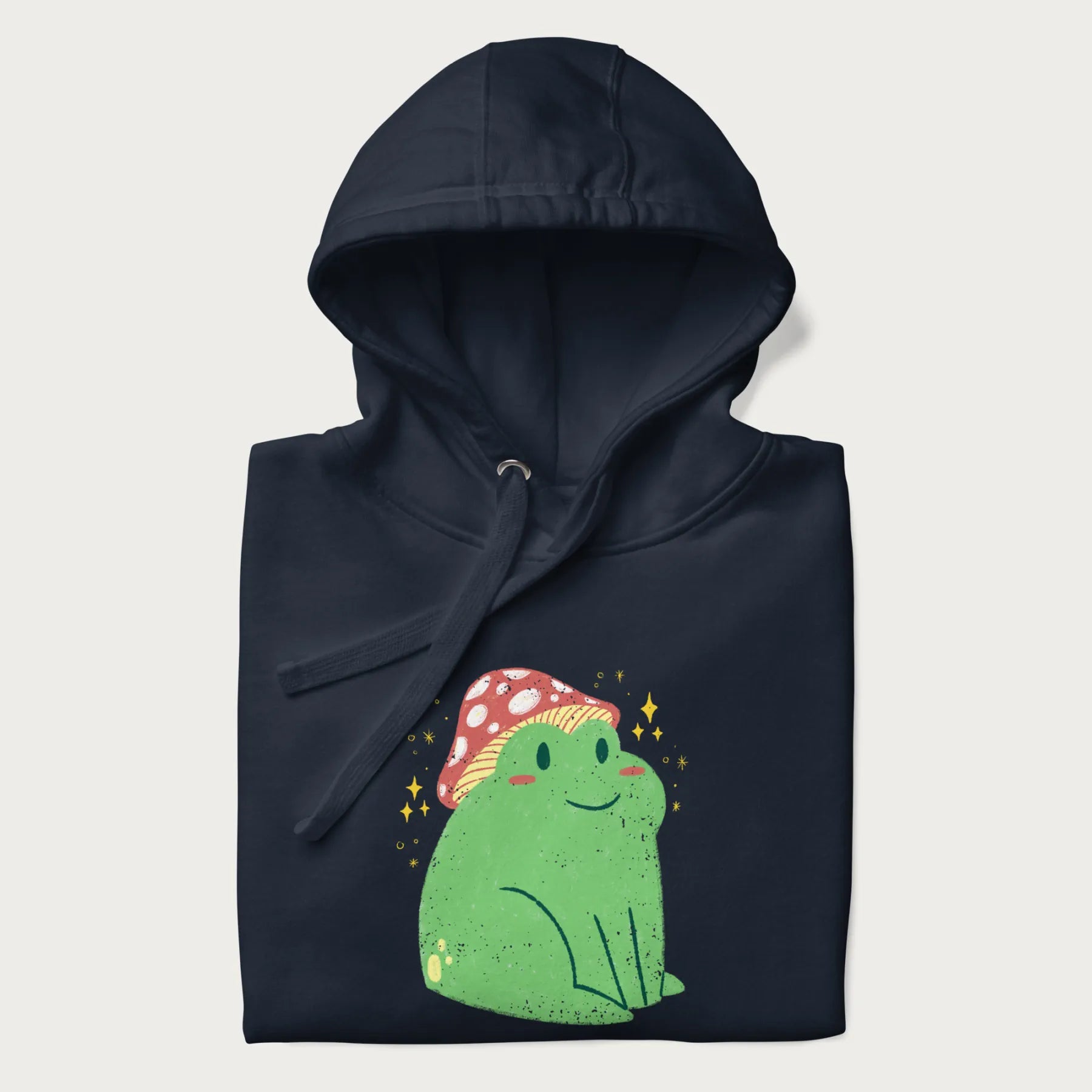 Folded navy blue hoodie with a graphic of a green frog wearing a mushroom cap surrounded by stars.