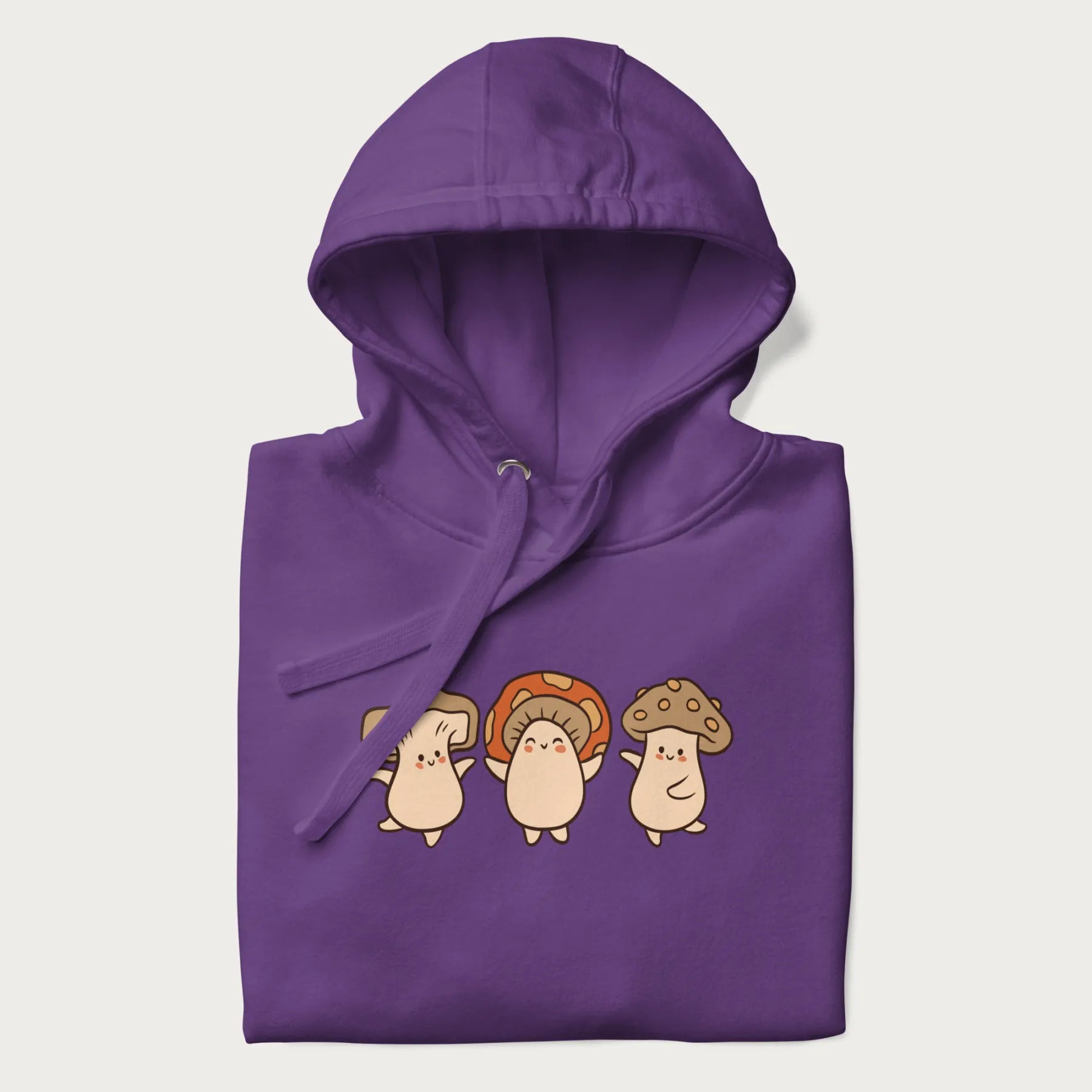 Folded purple hoodie with a graphic illustration of three cheerful dancing mushrooms.