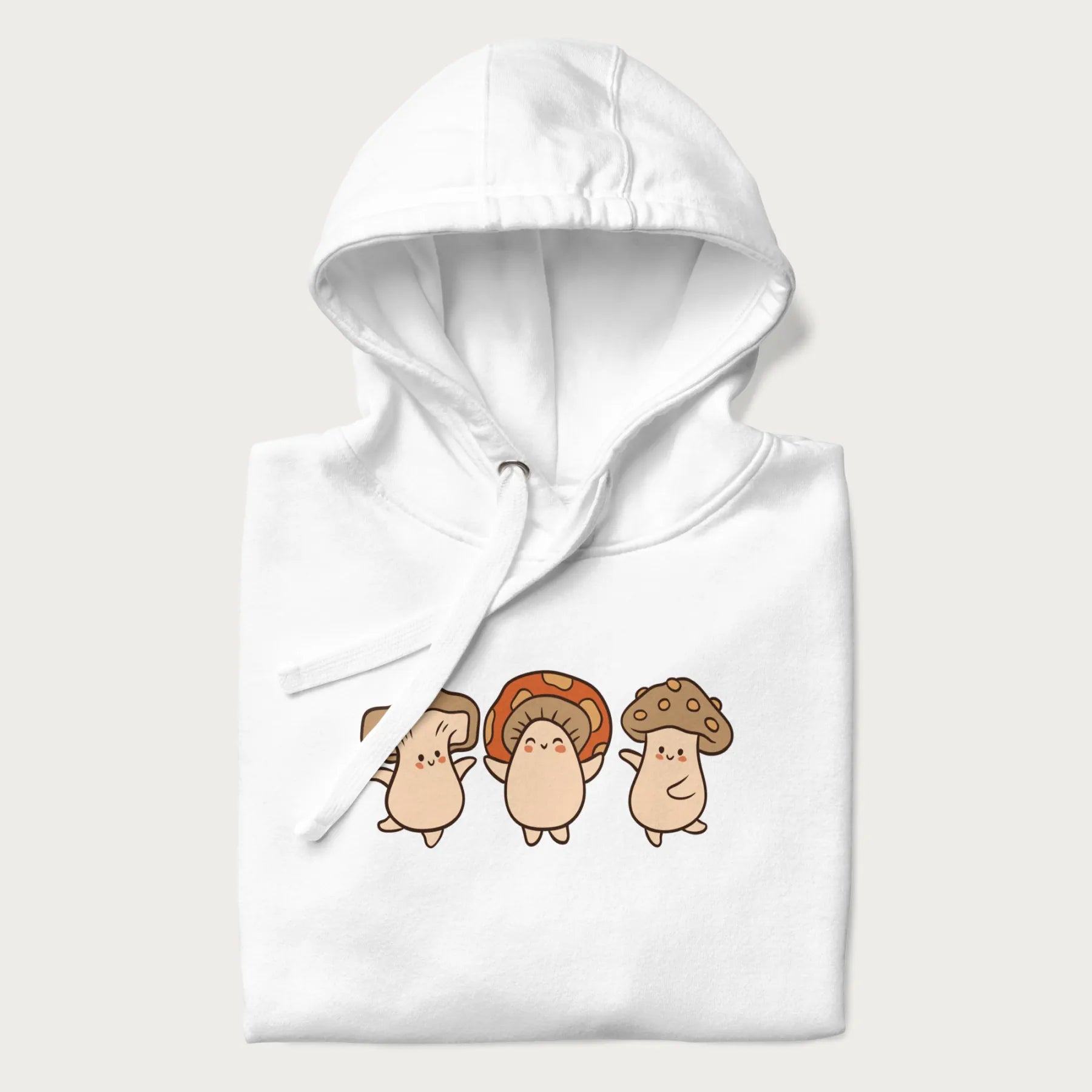 Folded white hoodie with a graphic illustration of three cheerful dancing mushrooms.