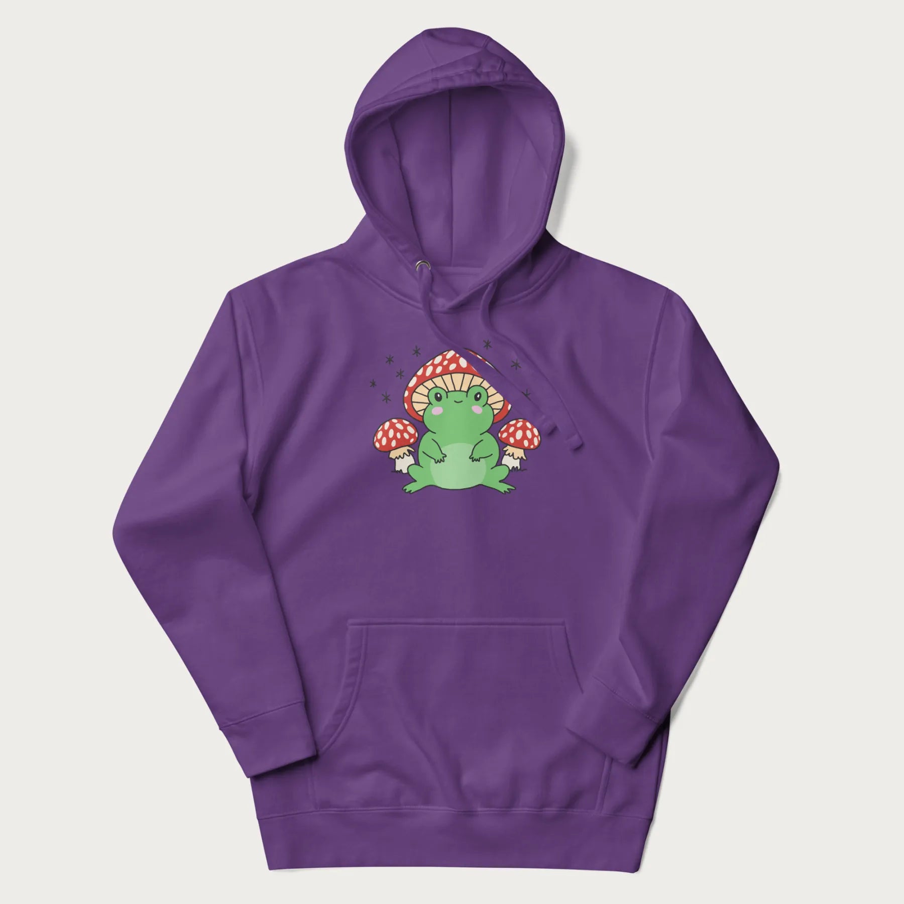 Purple hoodie will illustration of a cute green frog with red and white mushrooms.