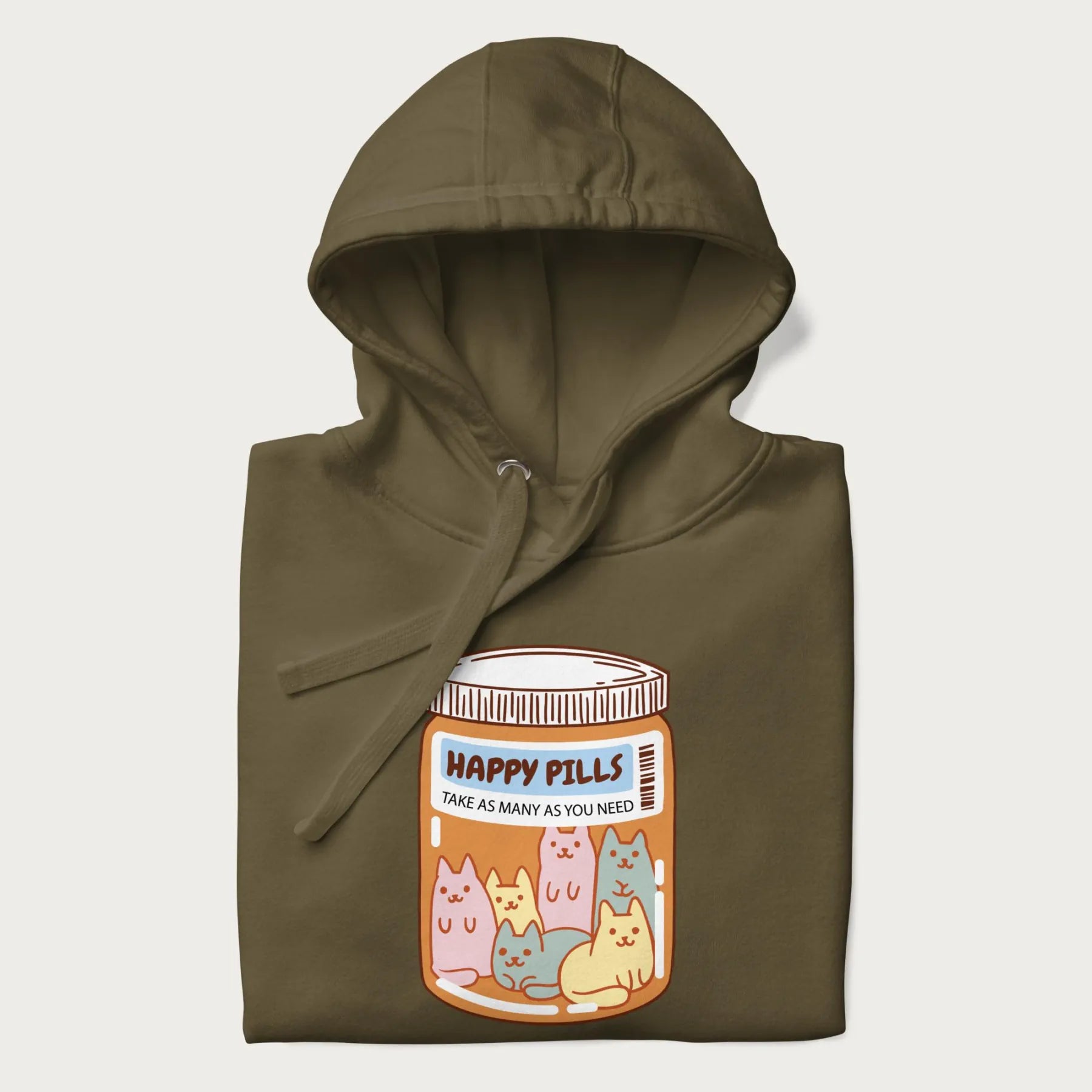 Cartoon cats in a pill bottle labeled 'Happy Pills' on a folded military green hoodie.