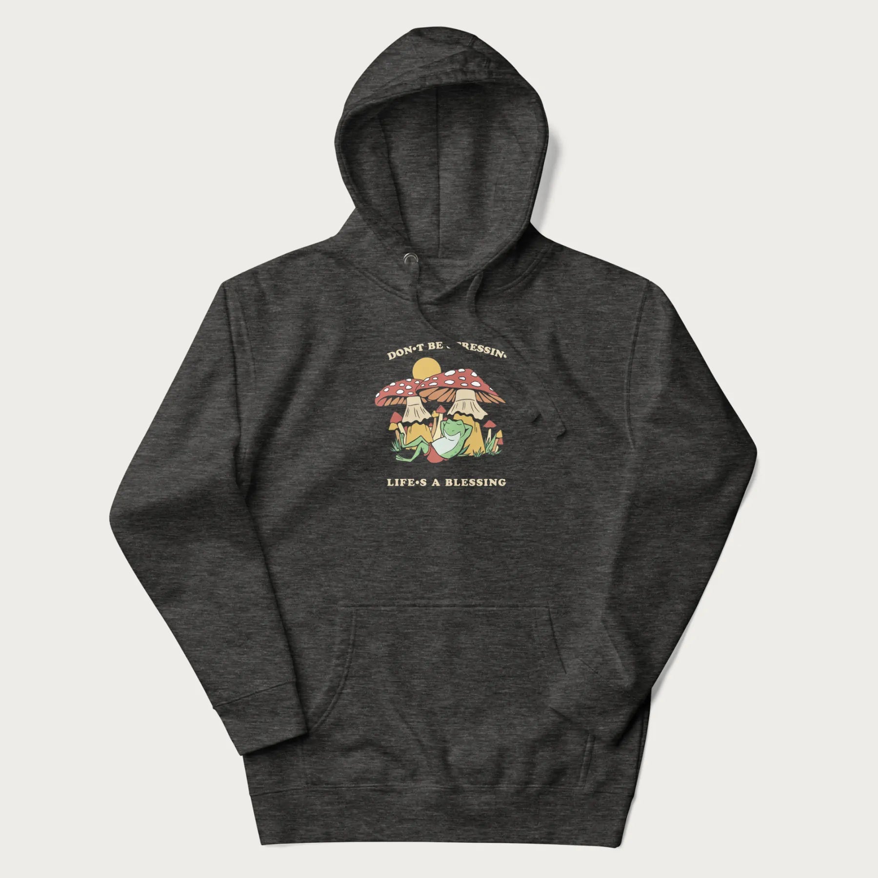 Dark grey hoodie with a graphic of a frog lounging under mushrooms and the phrases 'Don't Be Stressin' Life's a Blessing'.