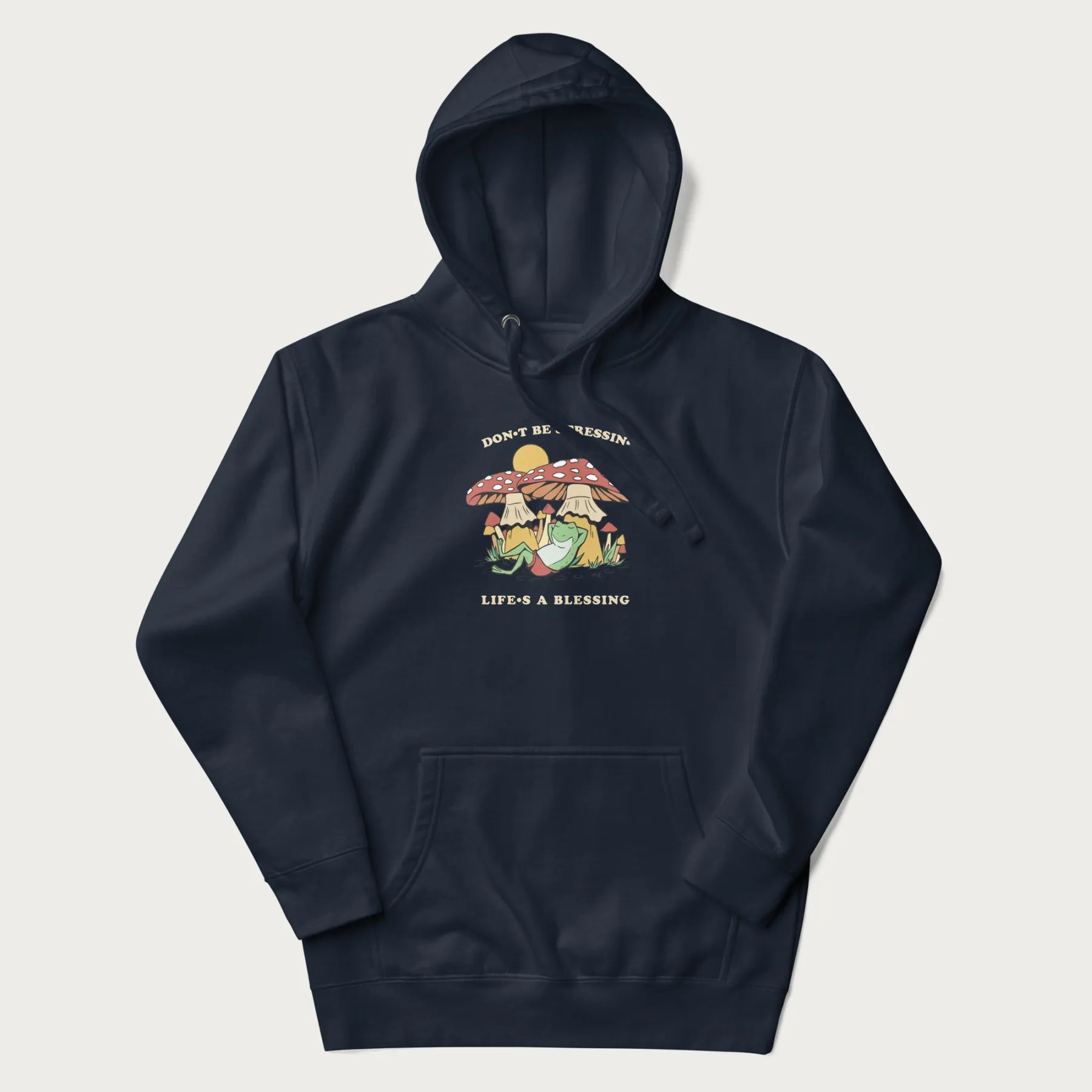 Navy blue hoodie with a graphic of a frog lounging under mushrooms and the phrases 'Don't Be Stressin' Life's a Blessing'.