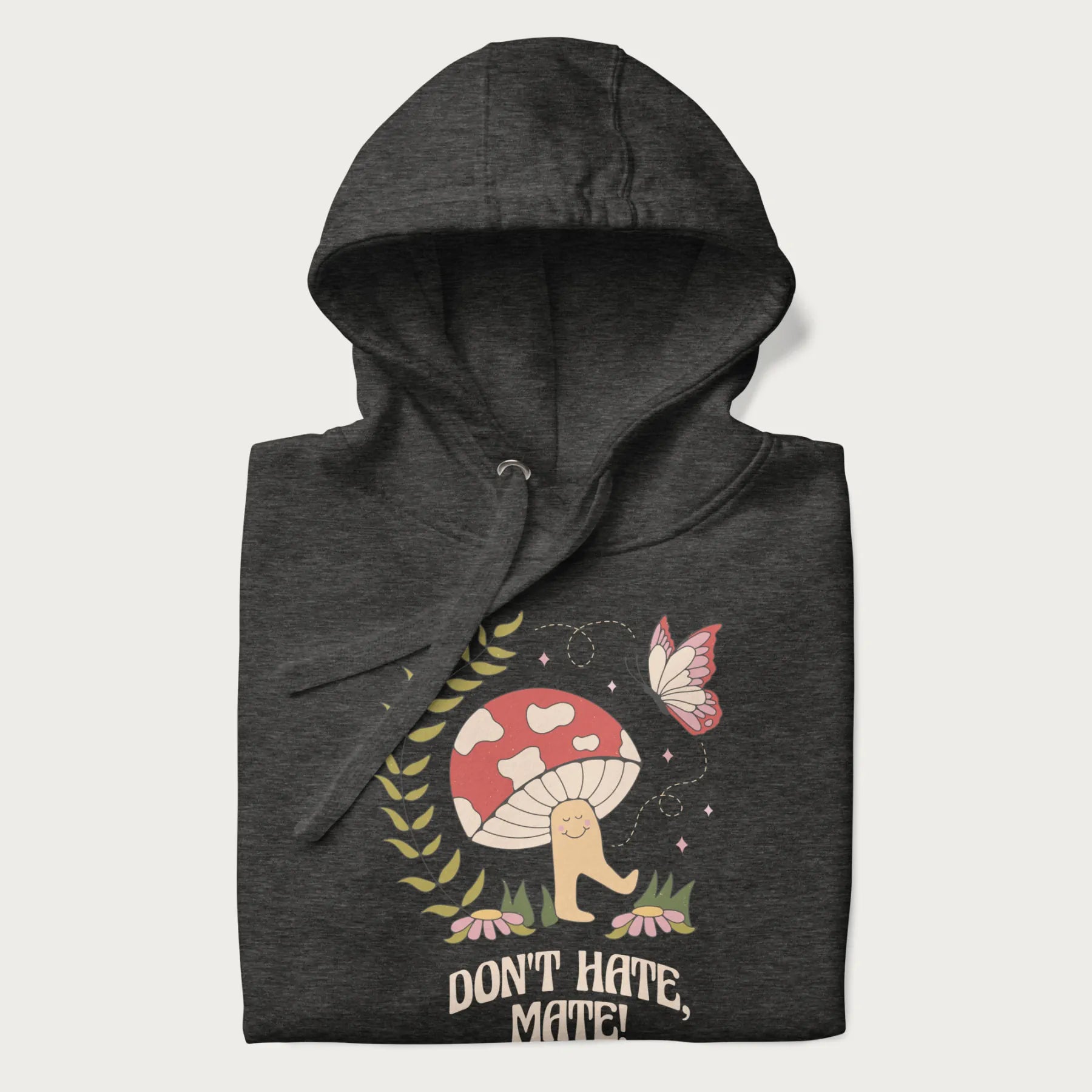 Folded dark grey hoodie featuring a cute mushroom graphic with the text "Don't Hate, Mate."