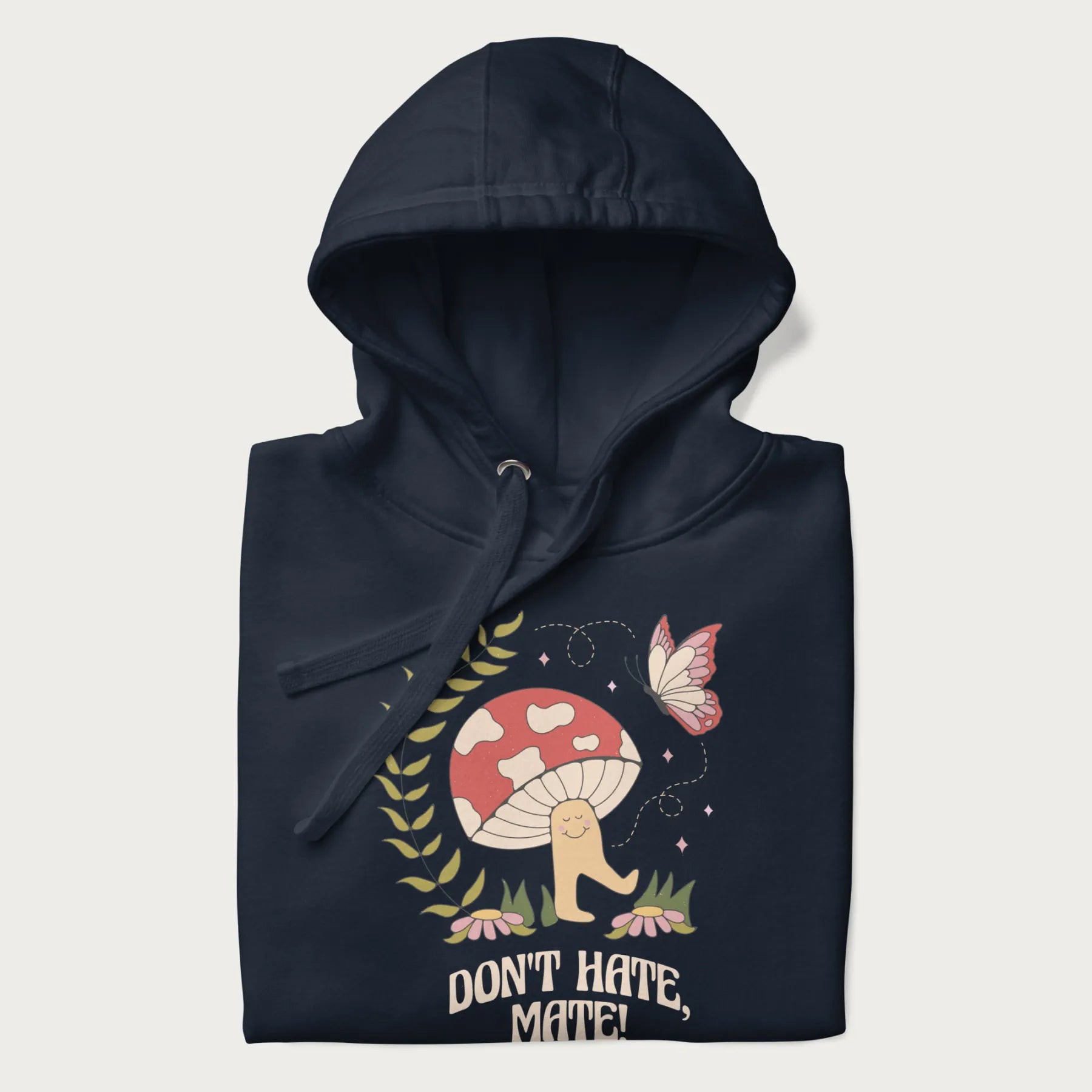 Folded navy blue hoodie featuring a cute mushroom graphic with the text "Don't Hate, Mate."
