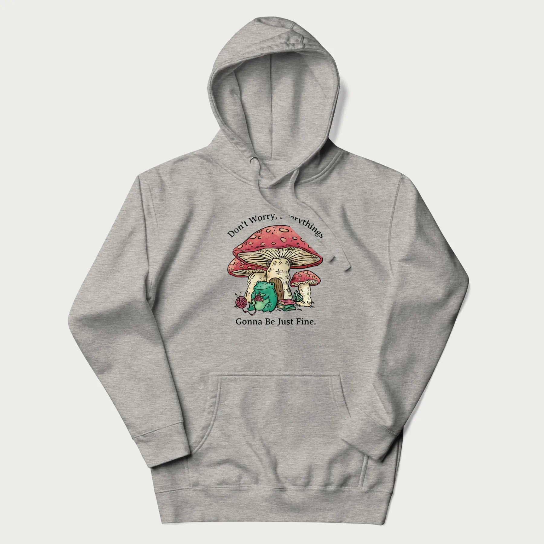 Light grey hoodie with a graphic of a frog knitting under a large mushroom with the text 'Don't Worry, Everything's Gonna Be Just Fine'.