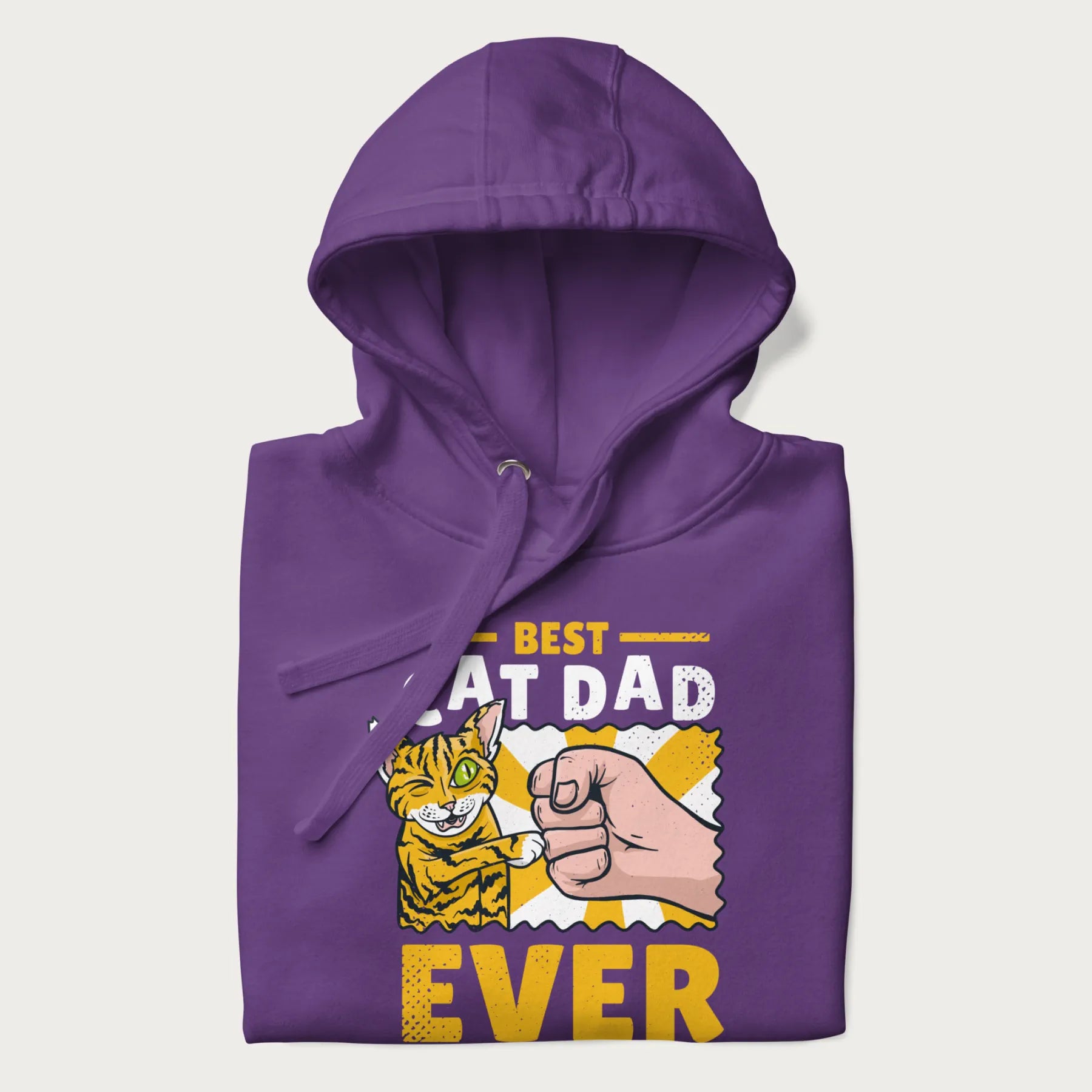Folded purple hoodie with a graphic of a tabby cat and a human fist bumping, with 'Best Cat Dad Ever' in bold letters.