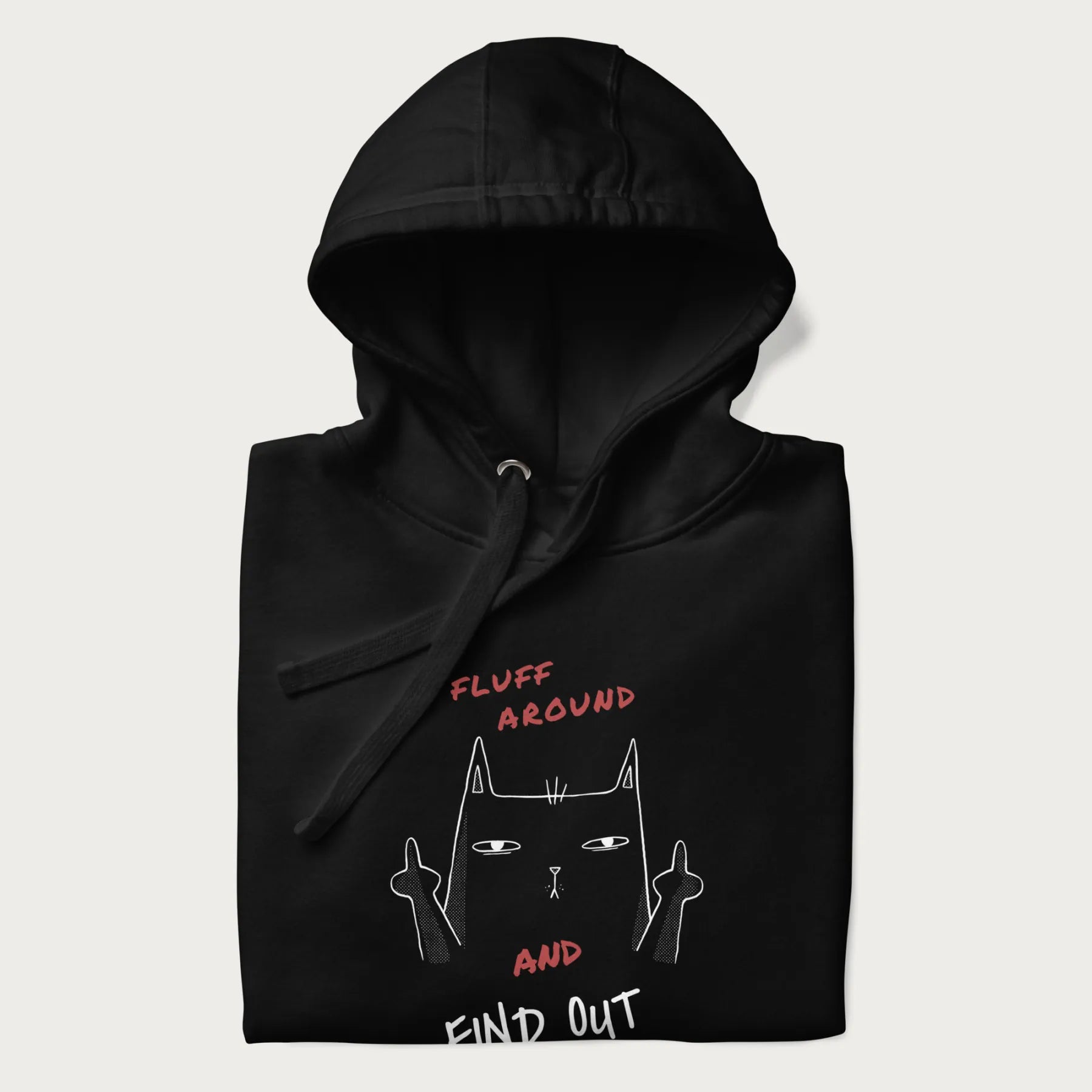 Folded black hoodie with a graphic of a cat raising its middle fingers and the text "FLUFF AROUND AND FIND OUT" in red.