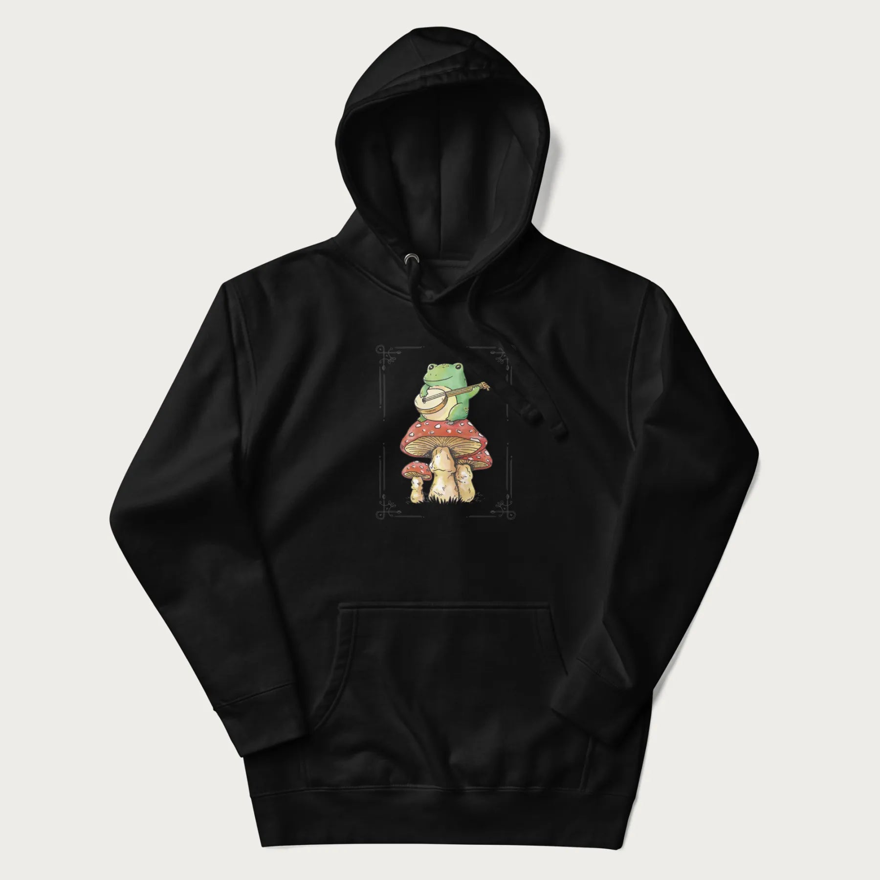 Black hoodie featuring a graphic of a frog playing a banjo on top of red mushrooms.