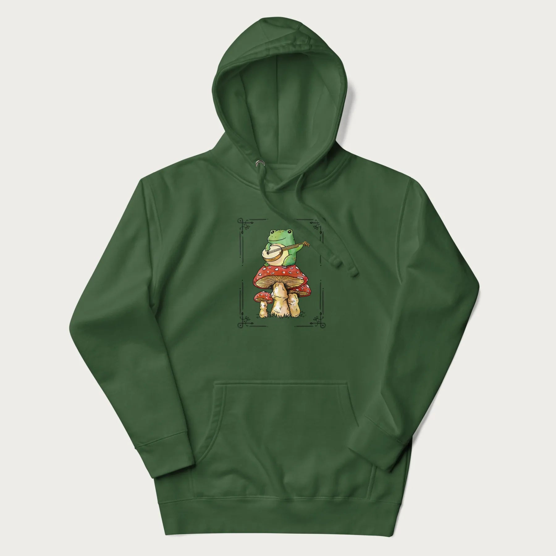 Forest green hoodie featuring a graphic of a frog playing a banjo on top of red mushrooms.