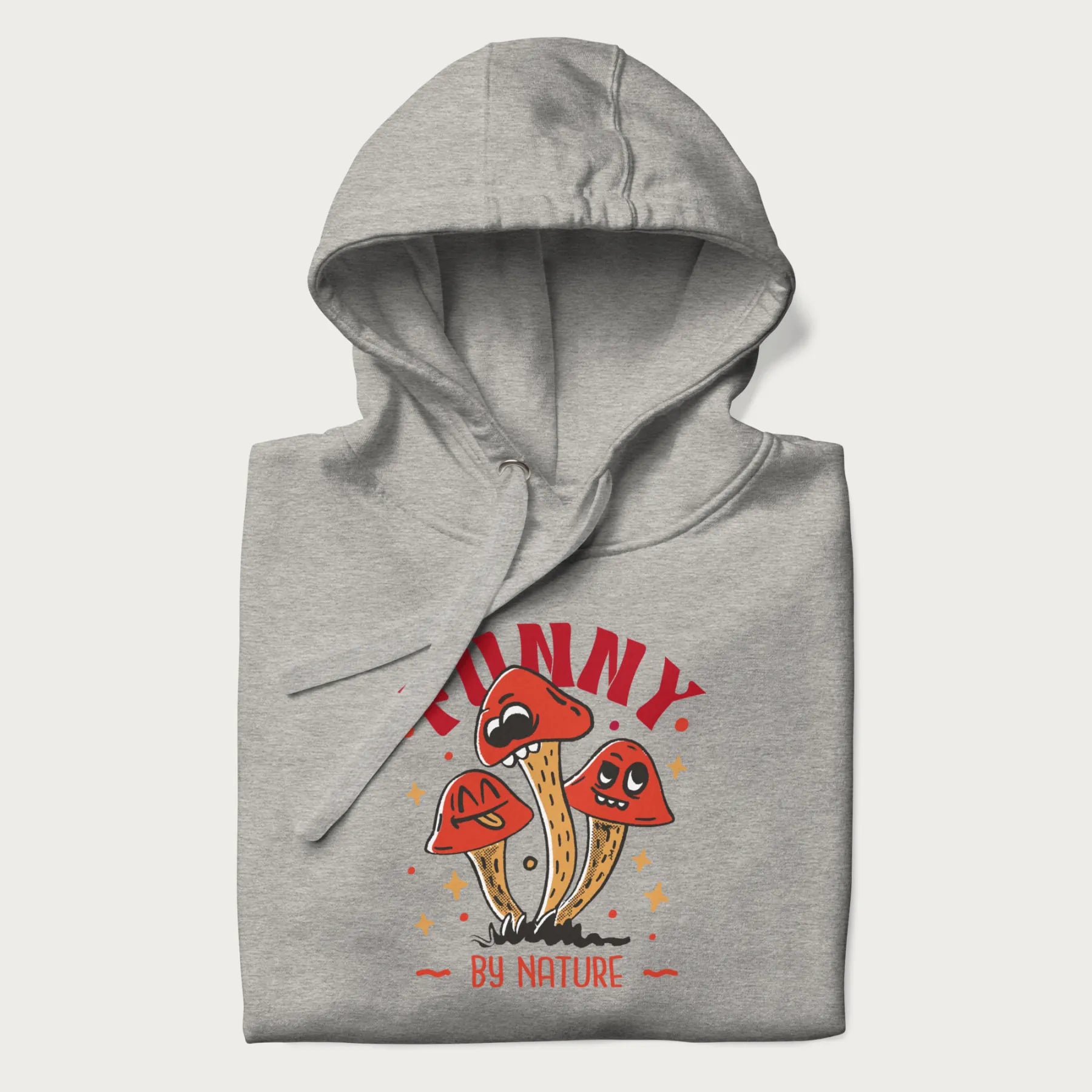 Folded light grey hoodie featuring a playful graphic of three mushrooms with expressive faces and the text "Funny by Nature."
