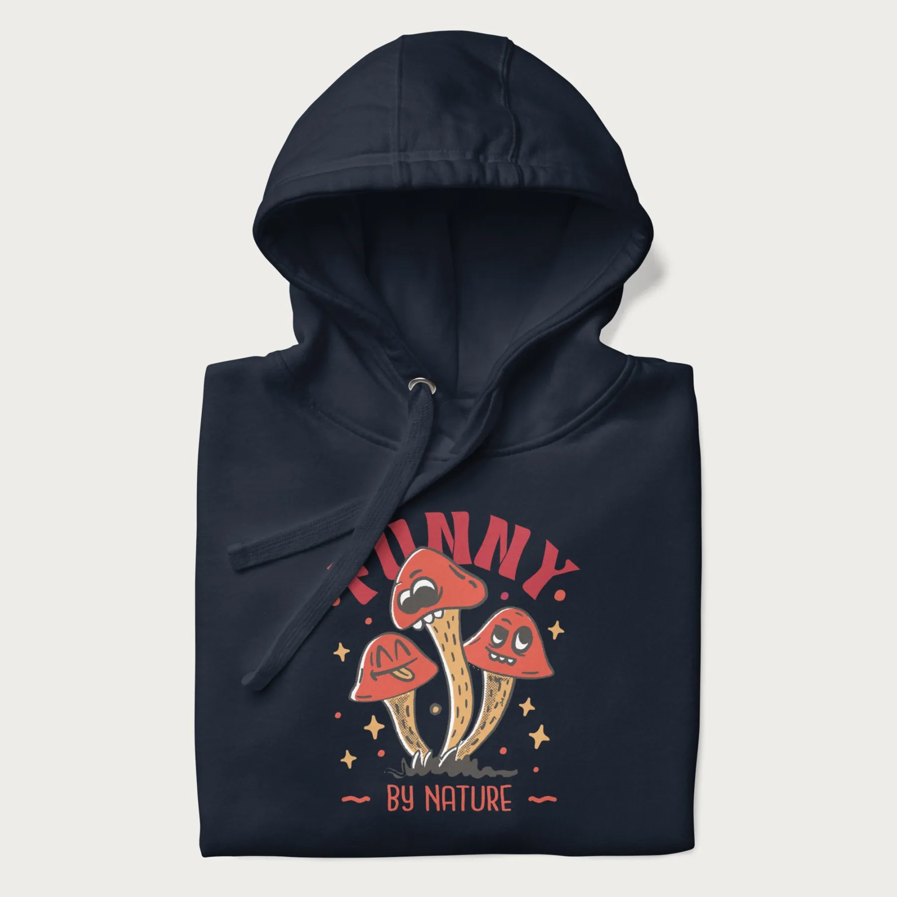 Folded navy blue hoodie featuring a playful graphic of three mushrooms with expressive faces and the text "Funny by Nature."
