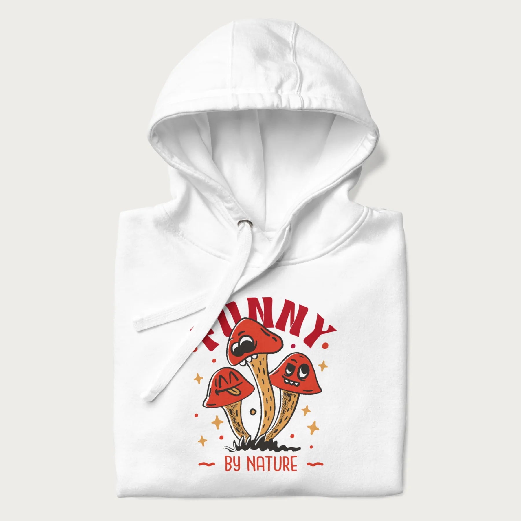 Folded white hoodie featuring a playful graphic of three mushrooms with expressive faces and the text "Funny by Nature."