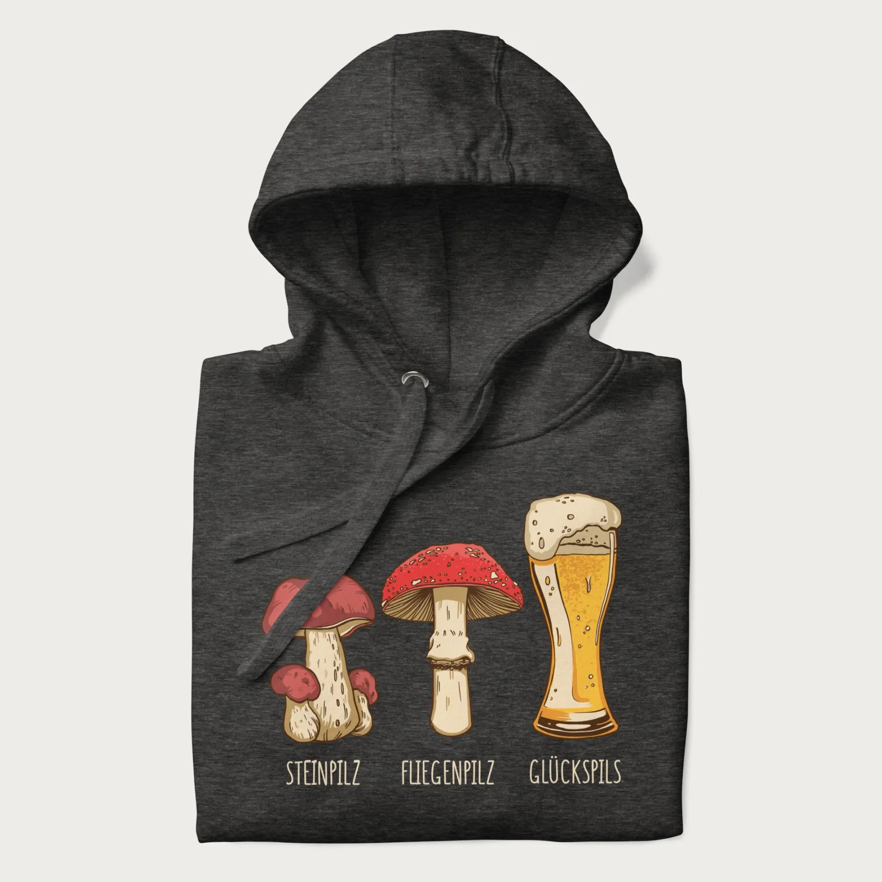 Folded dark grey hoodie with illustrations of a Steinpilz, Fliegenpilz, and a beer glass labeled Glückspils.