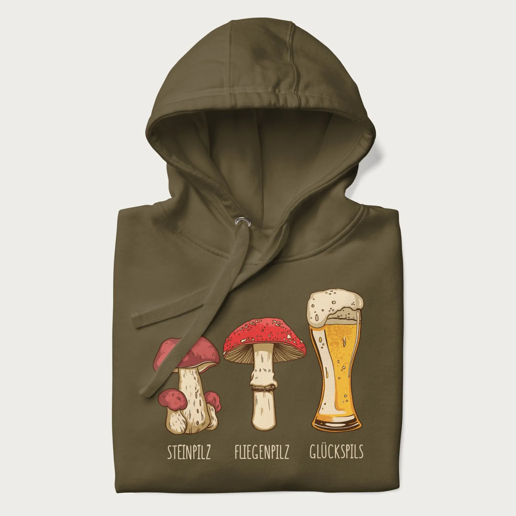 Folded military green hoodie with illustrations of a Steinpilz, Fliegenpilz, and a beer glass labeled Glückspils.