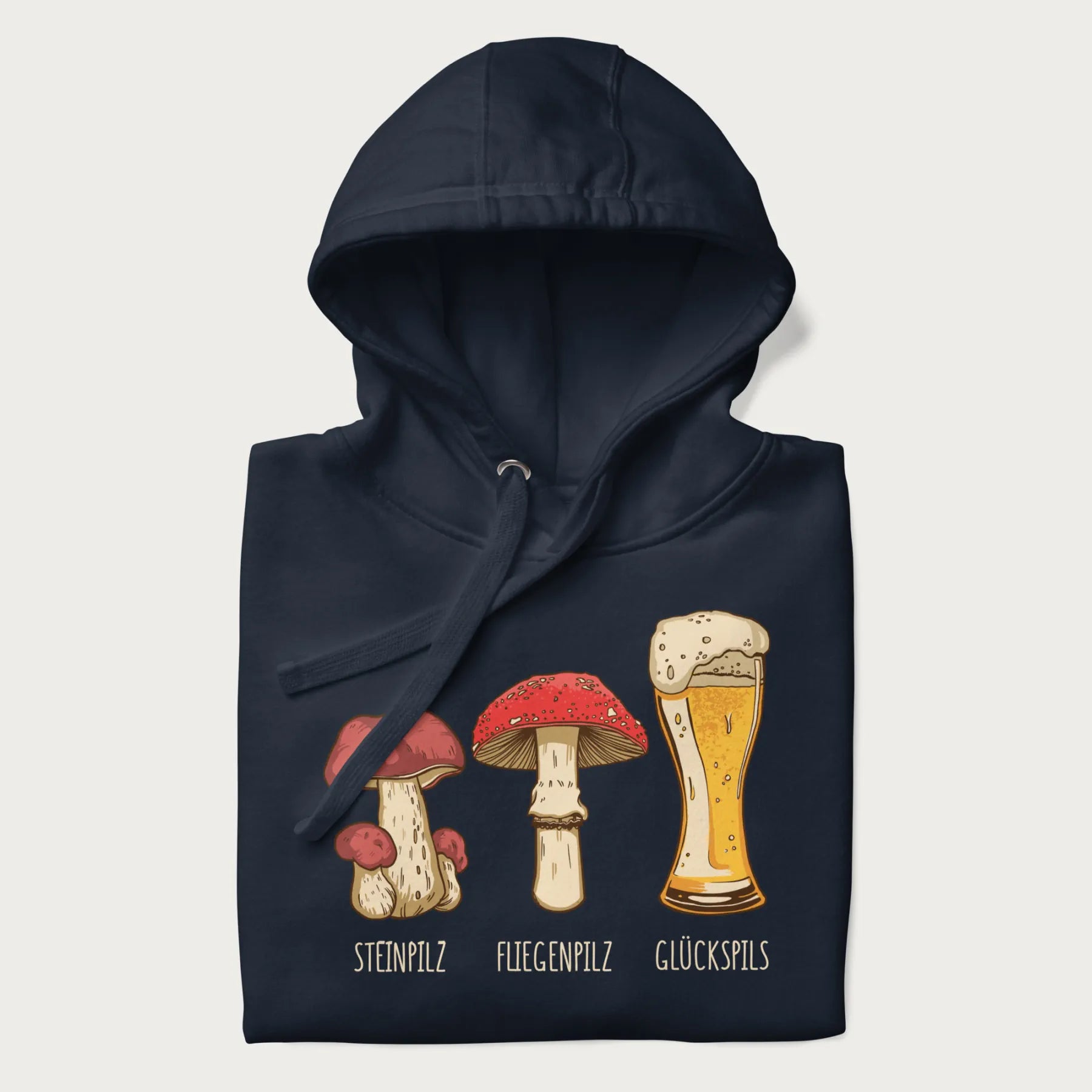 Folded navy blue hoodie with illustrations of a Steinpilz, Fliegenpilz, and a beer glass labeled Glückspils.