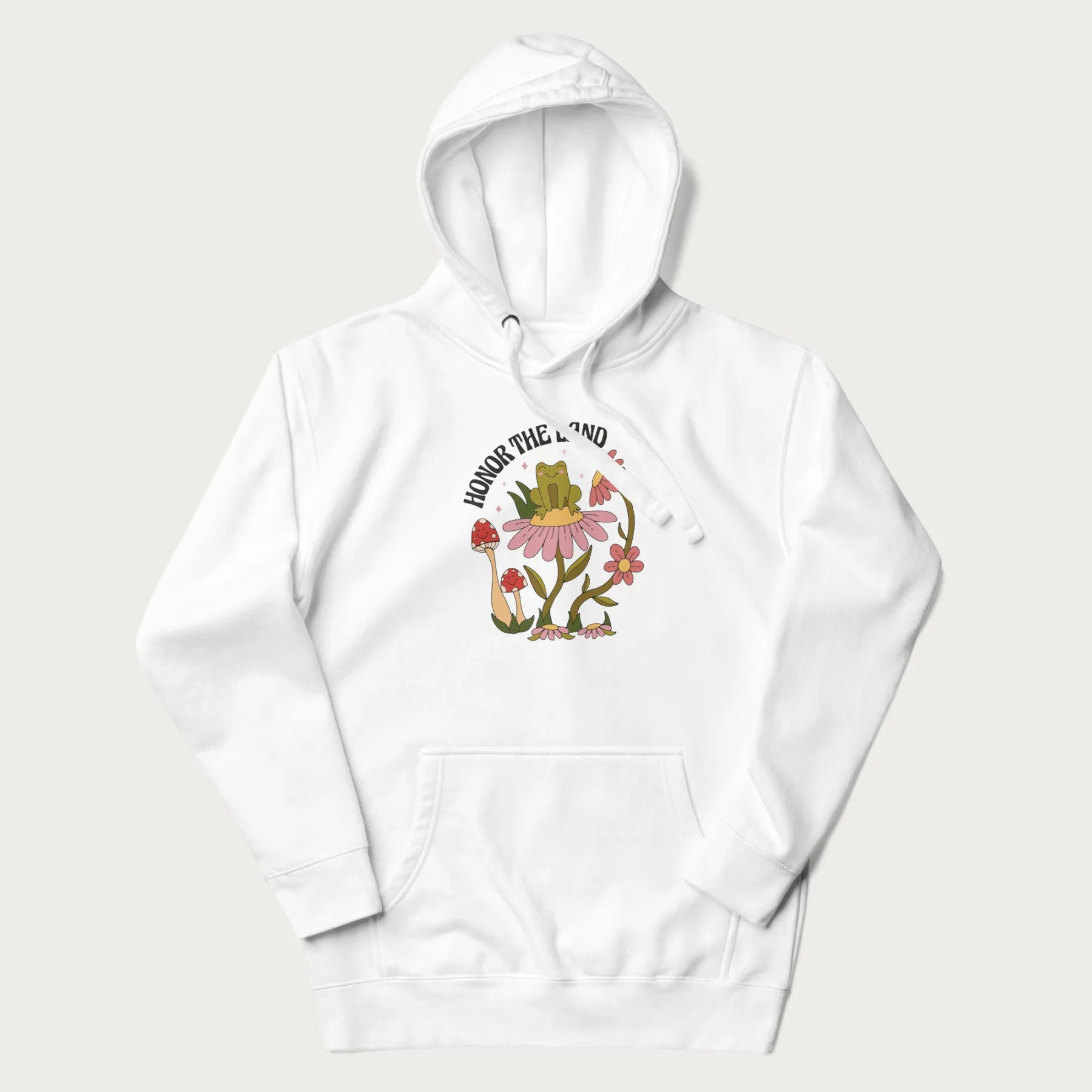 White hoodie with a graphic of a frog sitting on a flower, surrounded by mushrooms and flowers, with the text 'Honor the Land'.
