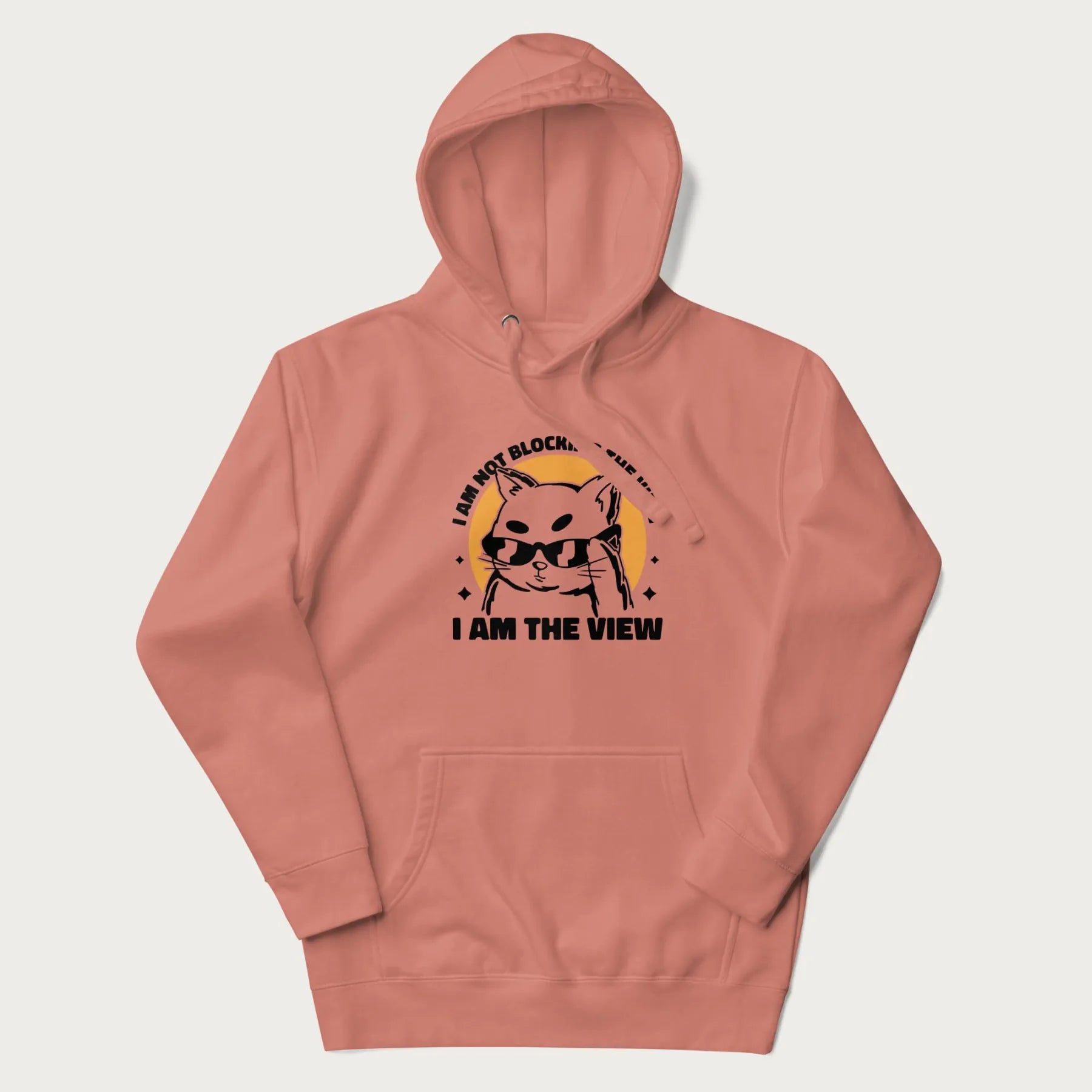 Light pink hoodie with a confident cat wearing sunglasses and the phrase 'I am not blocking the view, I am the view'.